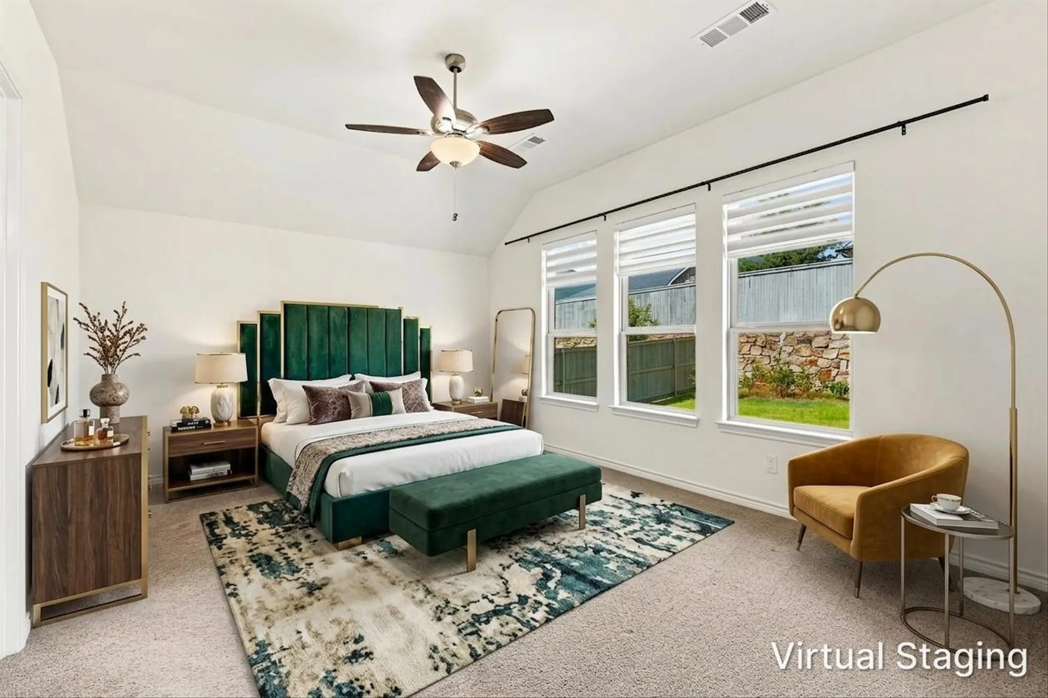 Vaulted ceiling with a ceiling fan, three large windows with roller shades, and plush carpeting
