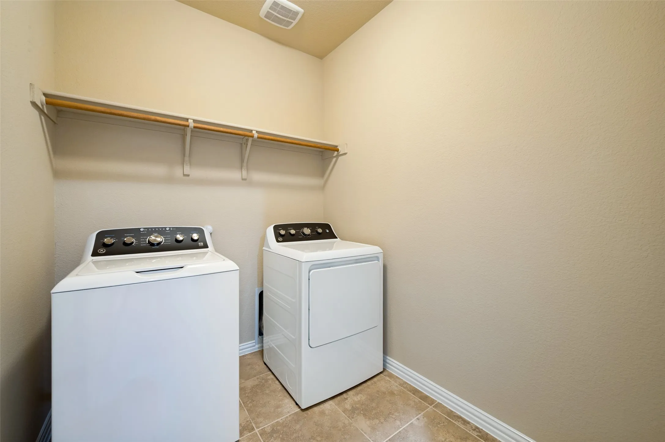 First floor laundry room off kitchen with built in shelf and drip dry hanging bar.