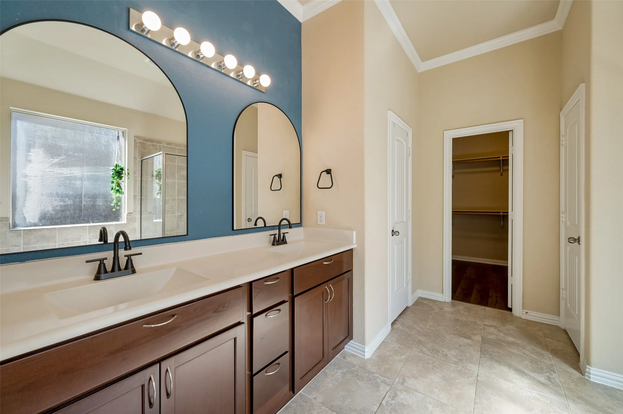 Primary bath with dual sinks, built in cabinets, linen closet and spacious walk in closet.
