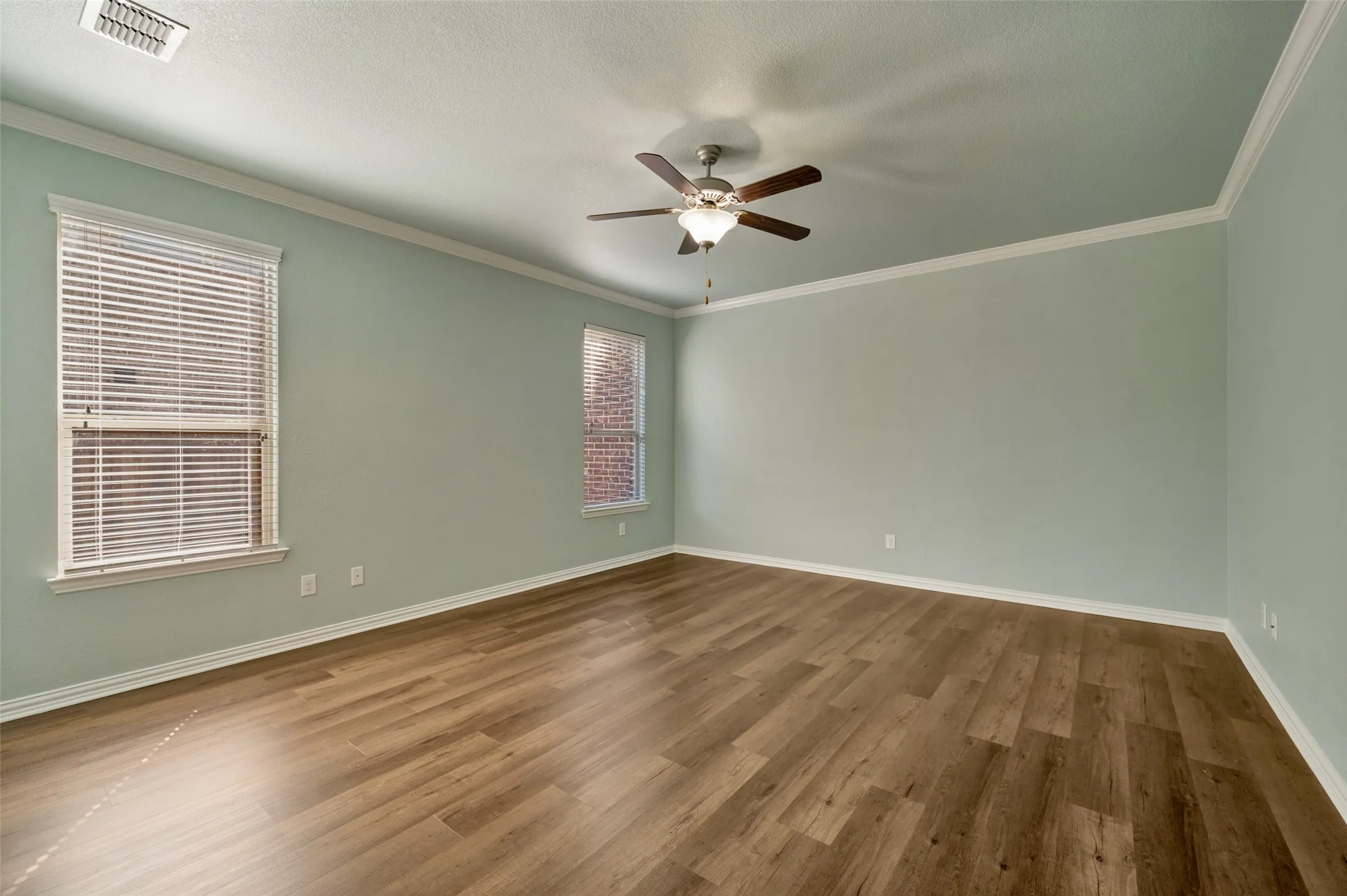 Spacious primary bedroom with ceiling fan, ensuite bath and large walk in closet.
