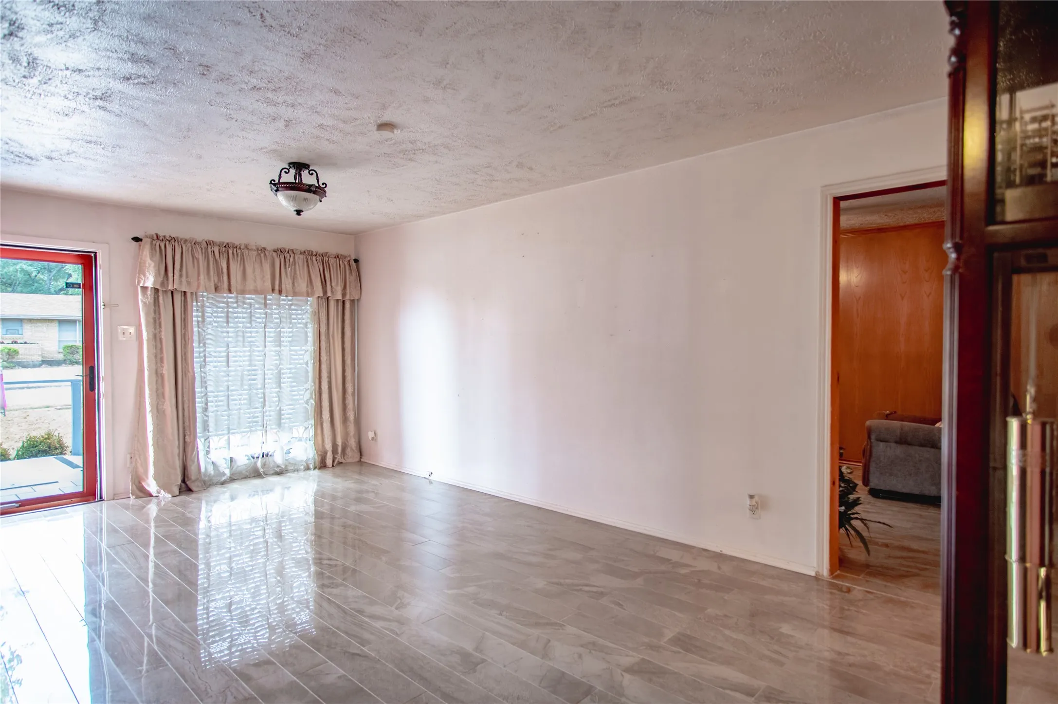 Ceramic tile flooring, textured ceiling, and a ceiling-mounted light fixture