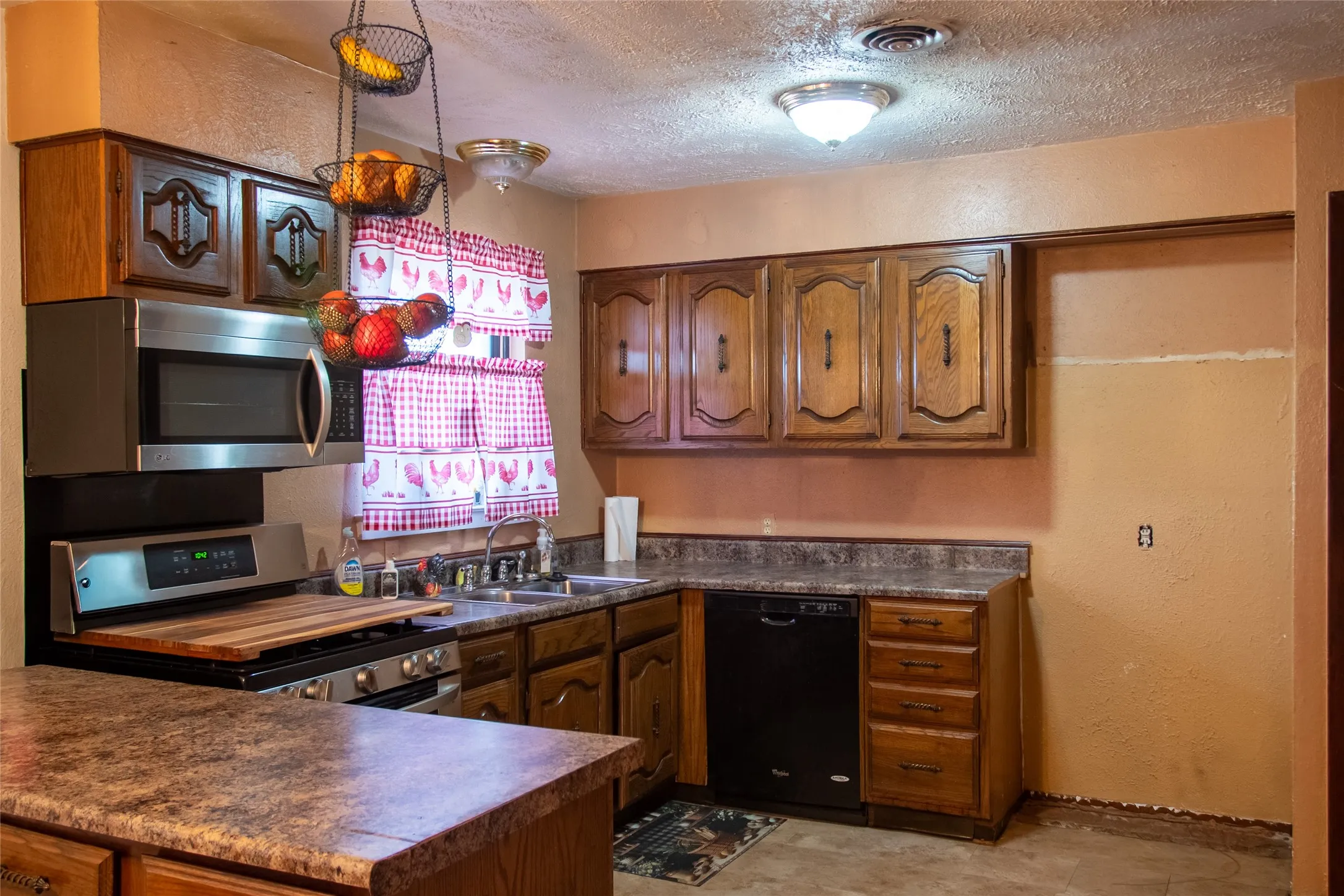 Wood-finish cabinetry paired with a stainless steel microwave and range