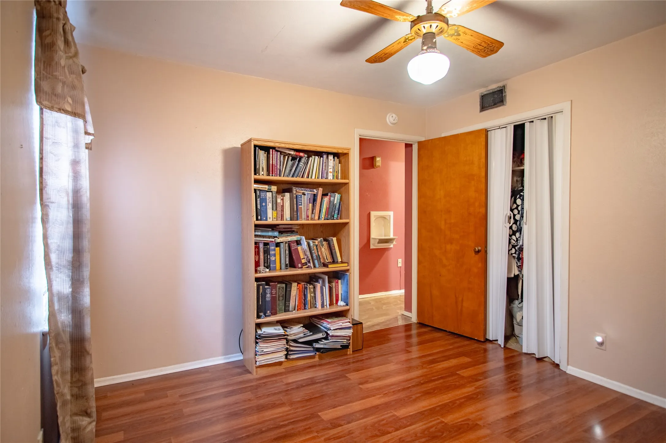 Luxury vinyl plank flooring with a ceiling fan light fixture and bifold closet doors