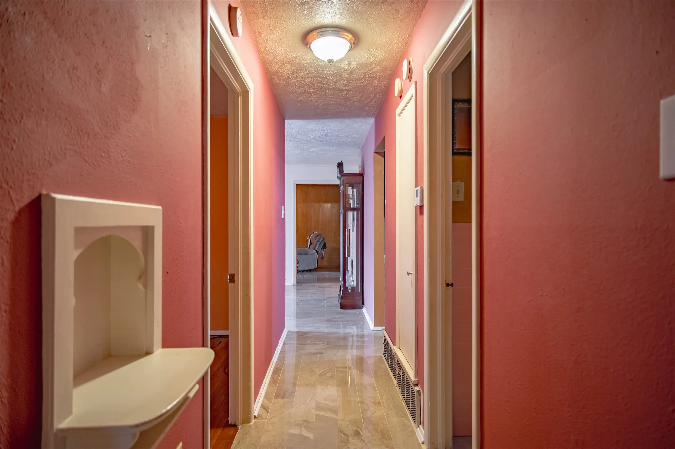Hallway with recessed lighting, tile flooring, and a built-in wall niche