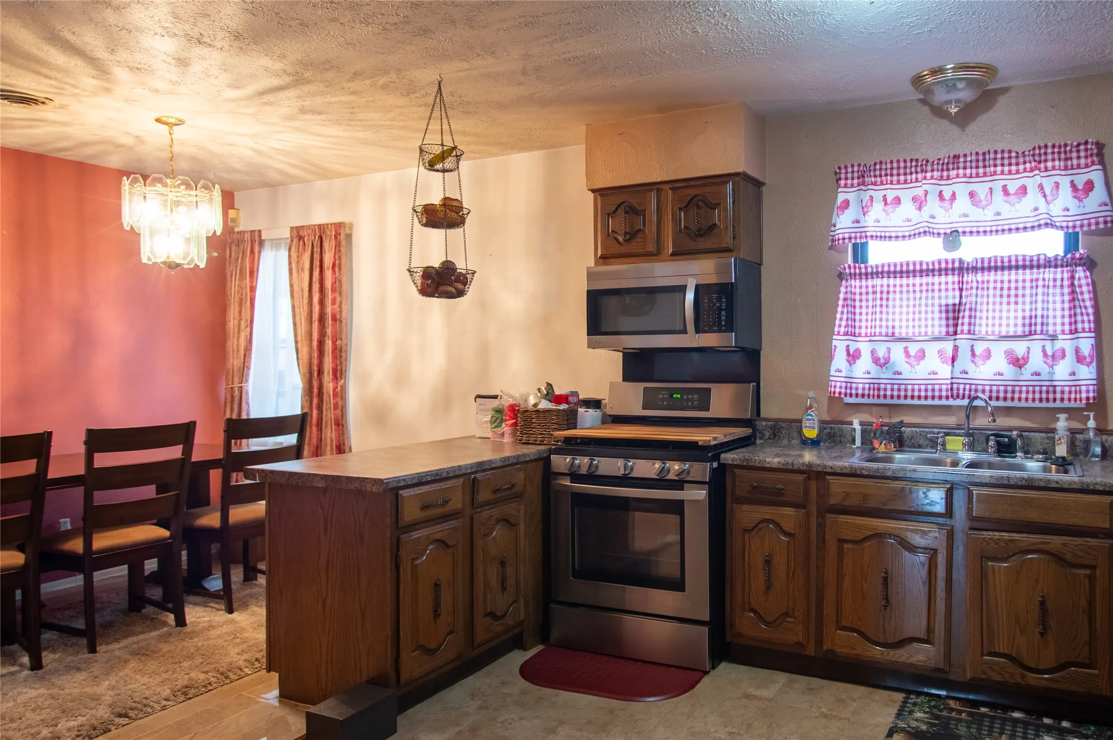 Kitchen with wood-finish cabinetry, stainless steel range, and built-in microwave