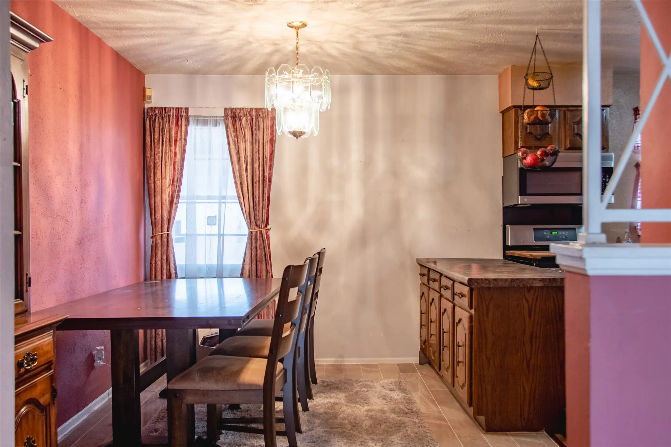 Built-in cabinetry with stone-finish countertops, stainless steel double wall ovens, and tile flooring