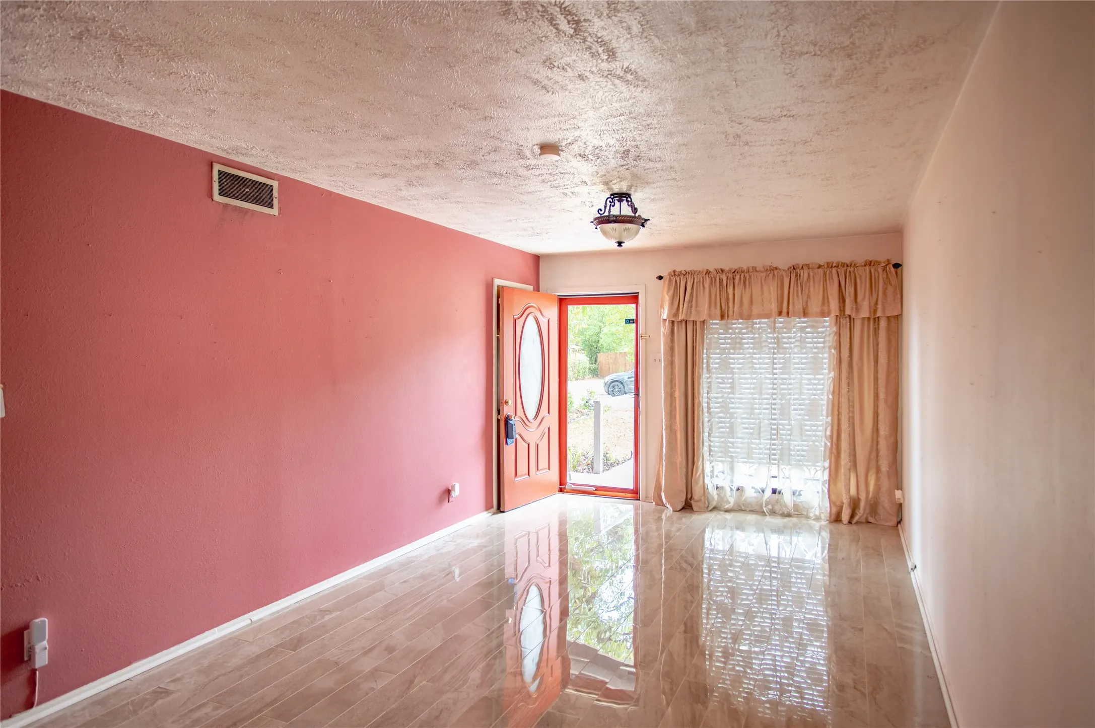 Luxury Vinyl Plank flooring throughout, featuring a prominent entryway with a decorative light fixture and a glass-paneled door