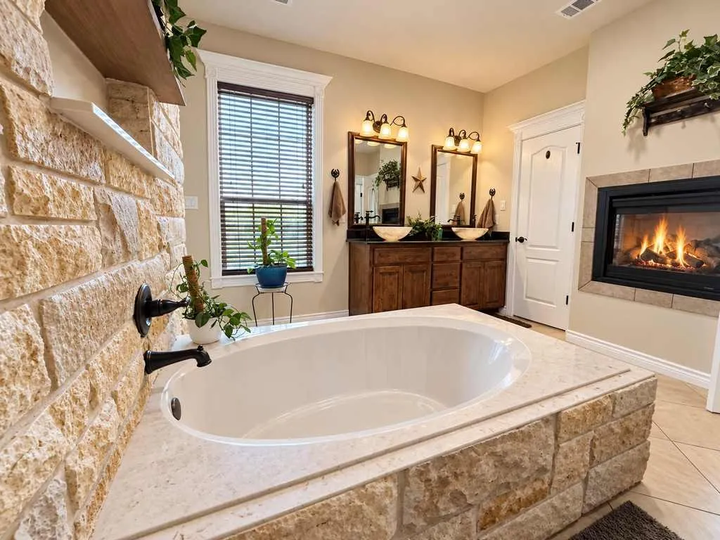Primary bath with a soaking tub and shared fireplace.