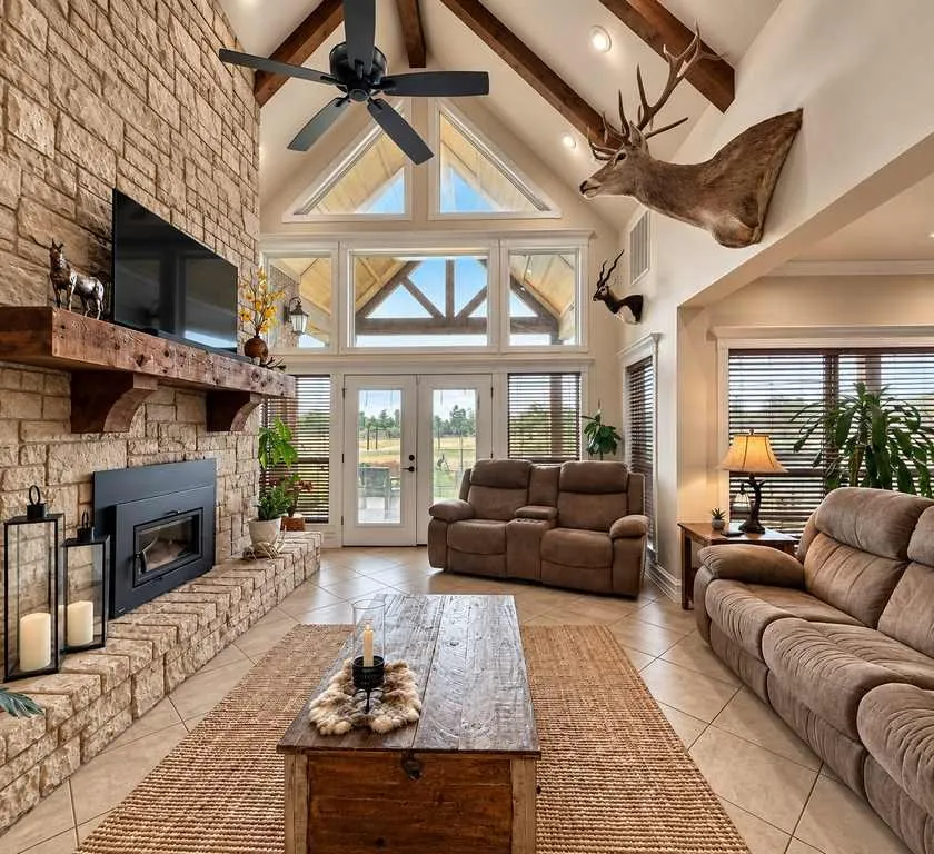Vaulted living room with exposed beams and a wall of windows.