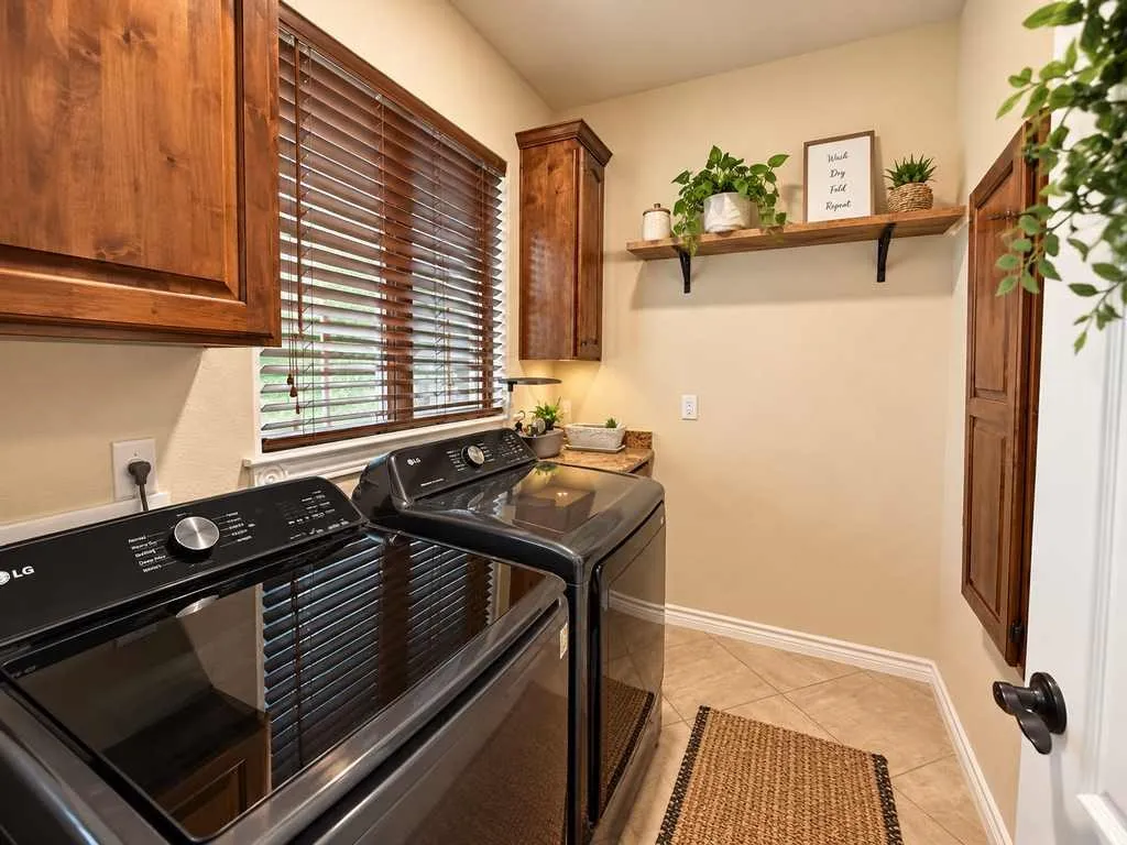 Laundry room with upper cabinets and a hanging rod.