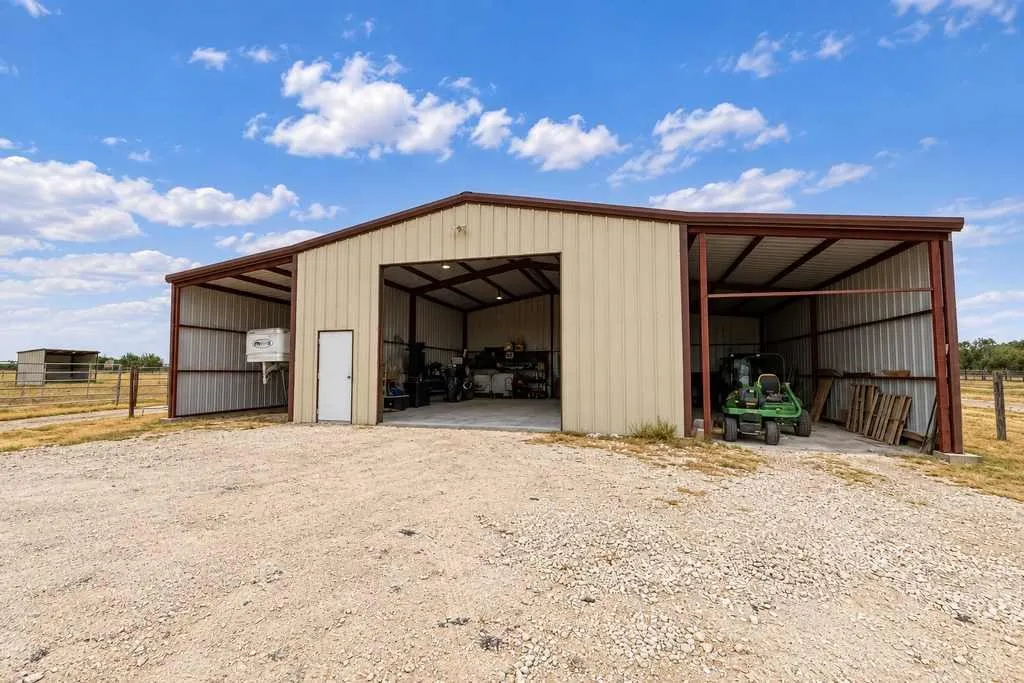 30×40 shop with a large overhead door and adjoining enclosed overhangs
