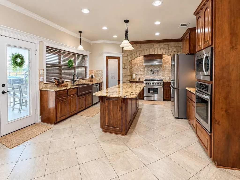 Spacious kitchen with wood cabinetry, granite countertops and a center island.