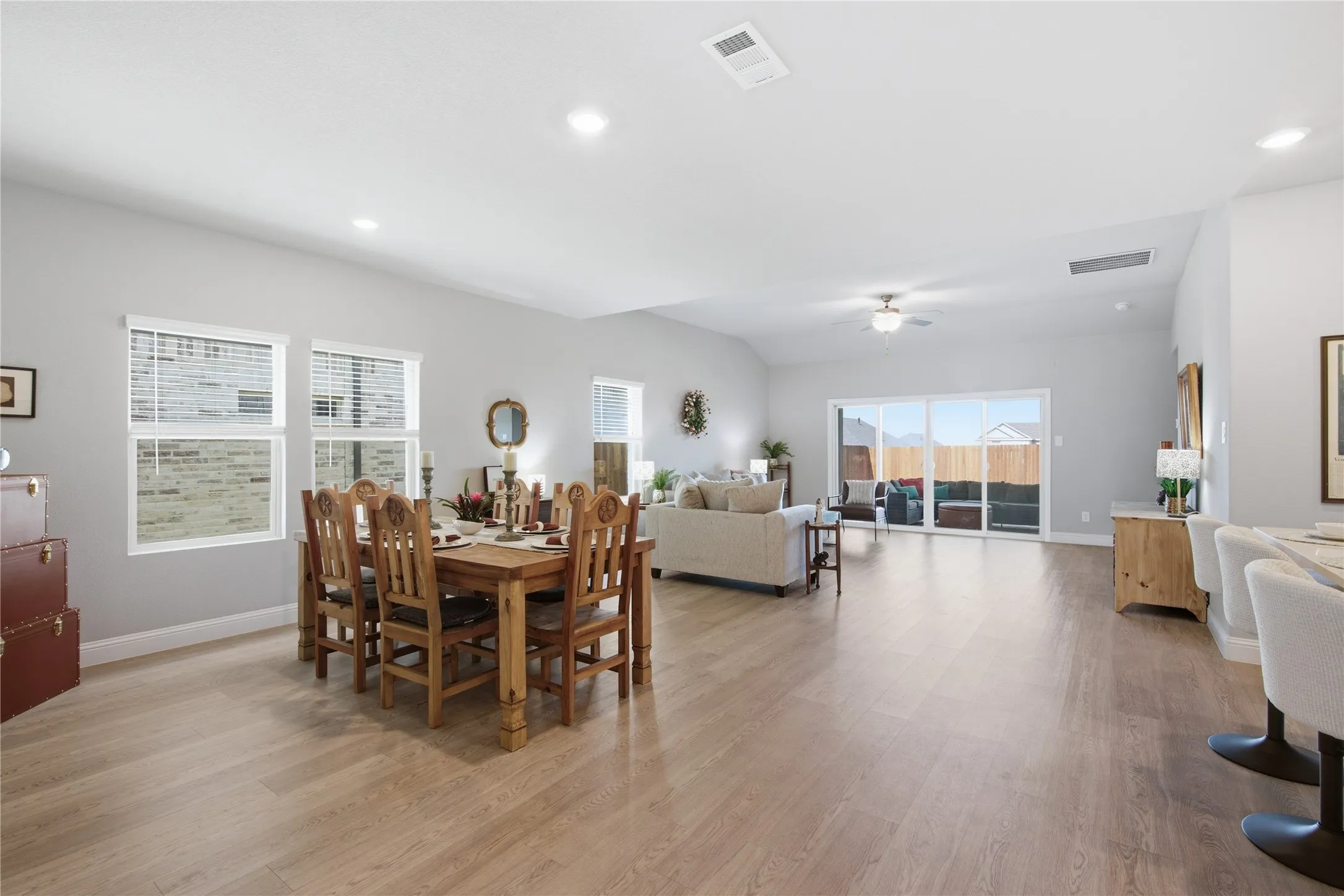 Open-concept living area with light wood-finish flooring, recessed lighting, and a ceiling fan