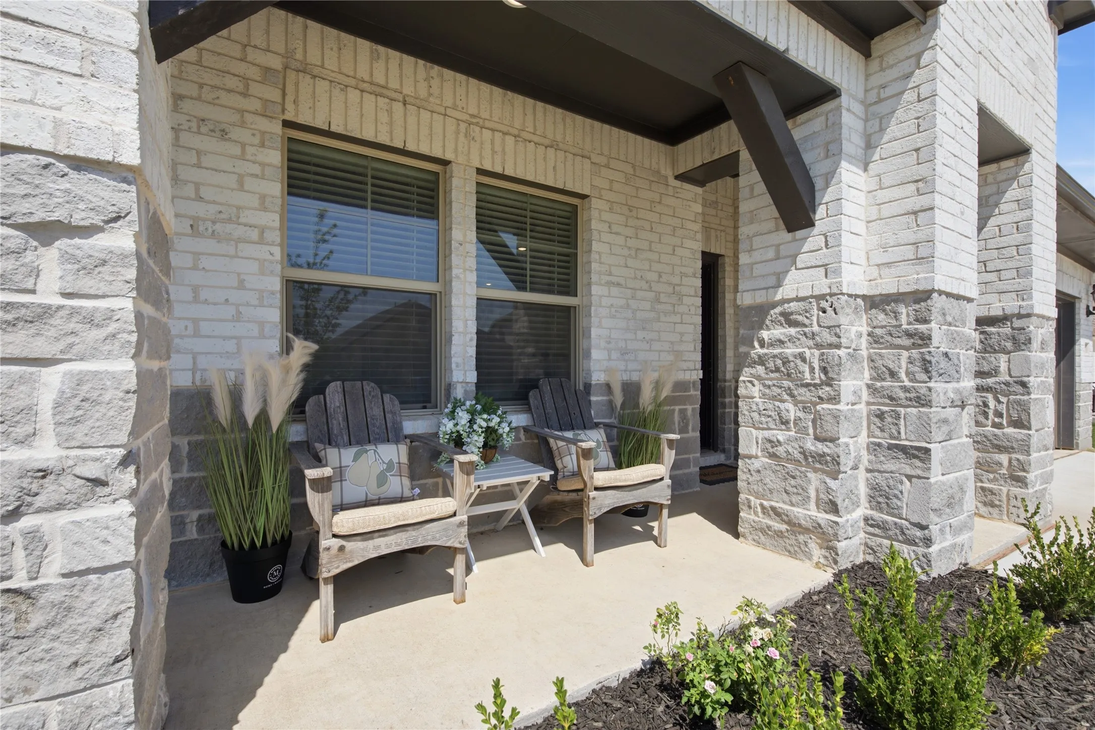 Covered concrete porch with mixed brick and stone facade