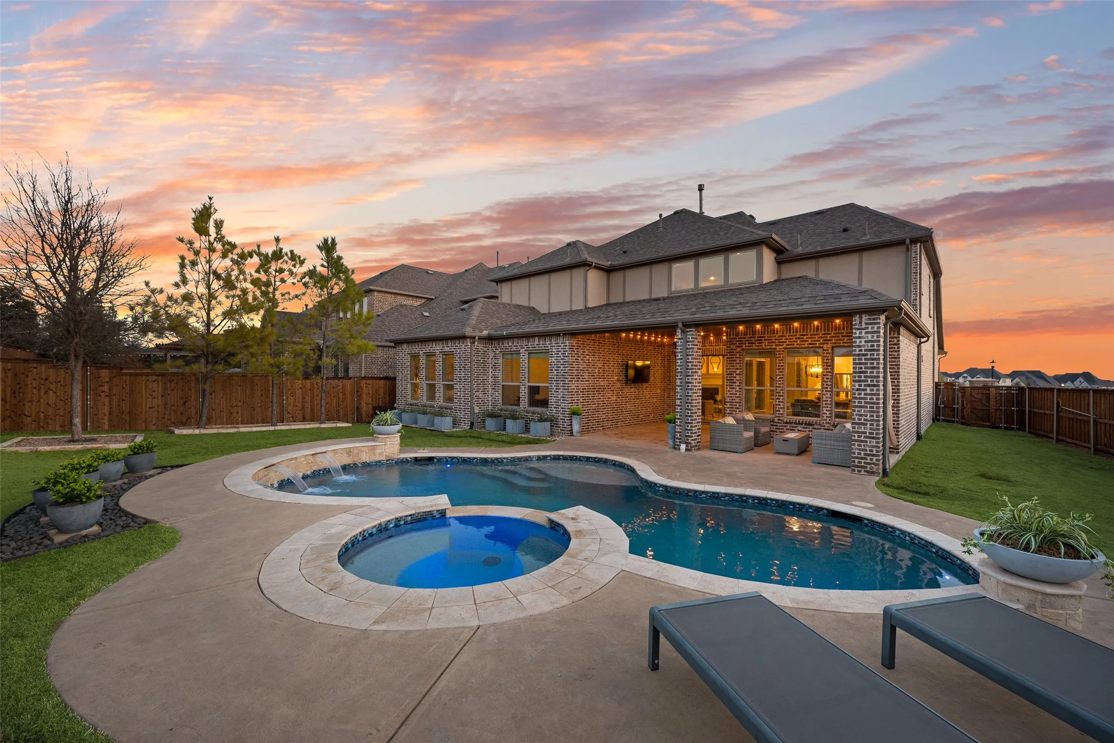 Expansive backyard featuring a freeform swimming pool, integrated spa, and a covered patio with string lighting