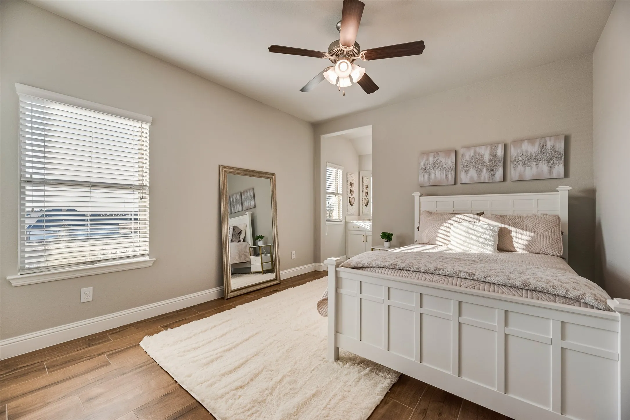 Wood-finish flooring with neutral wall tones and a ceiling fan
