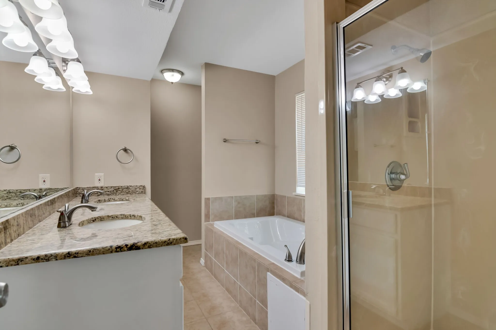 Unit A - Dual vanity with stone-finish countertop, undermount sinks, and brushed nickel fixtures