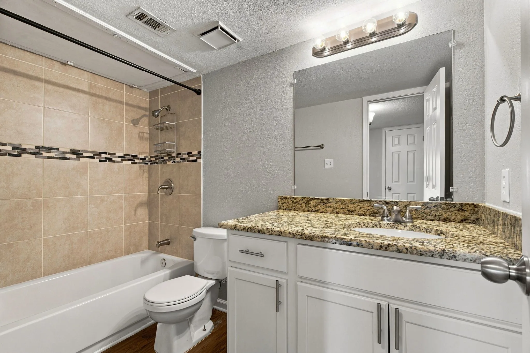 Unit D -White vanity with brushed nickel hardware, granite countertop, undermount sink, and wall-mounted mirror