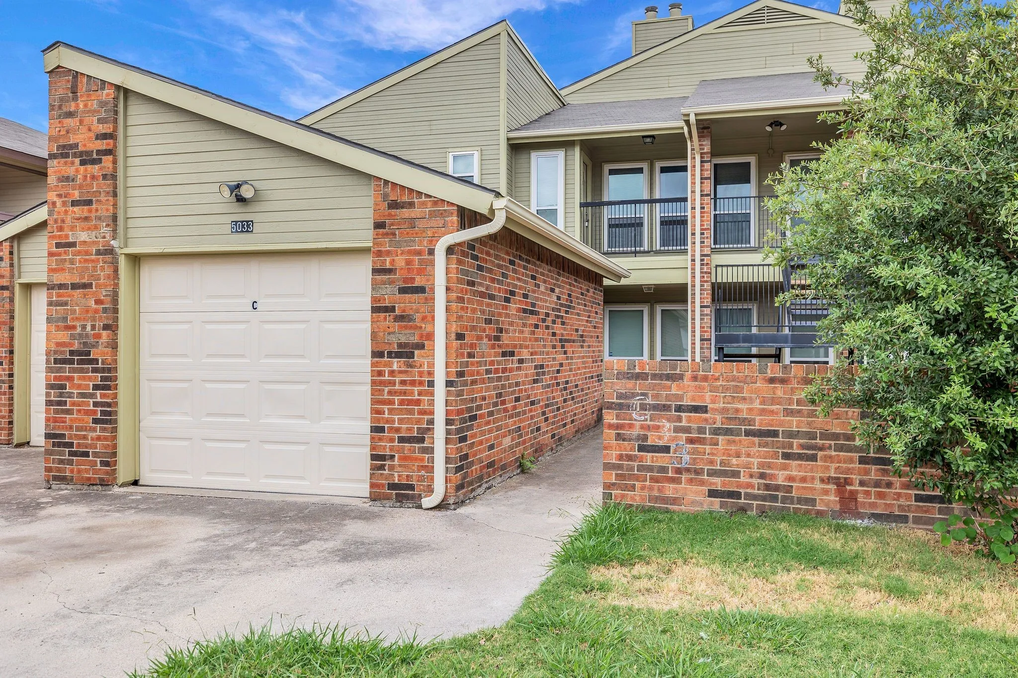 Brick and siding exterior with a single-car garage and concrete driveway