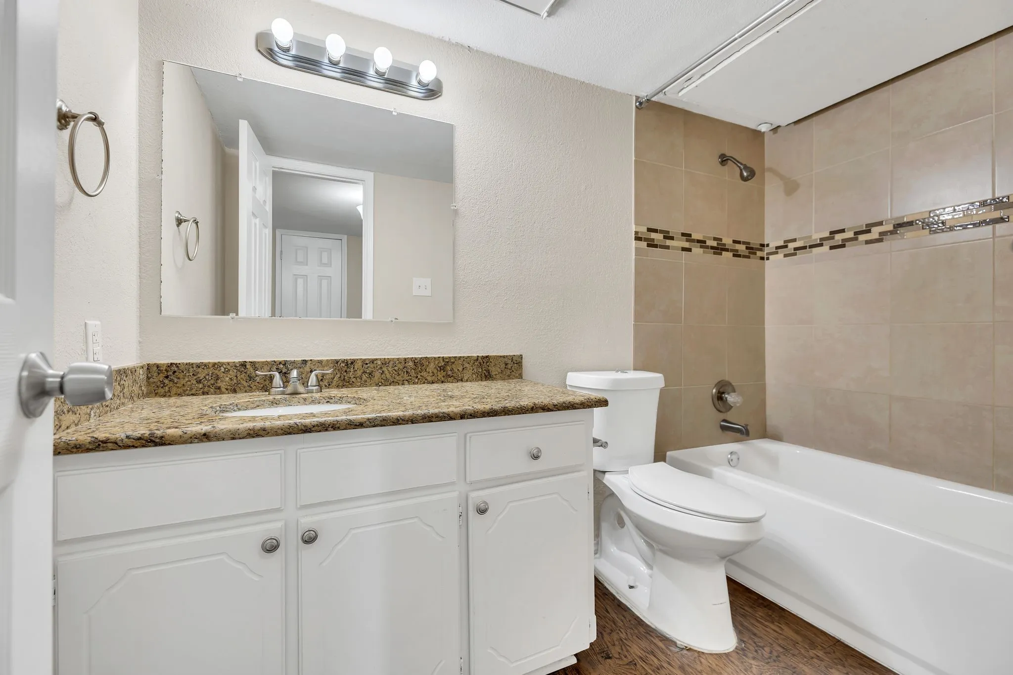 Unit C- White vanity with panel detailing, granite-finish countertop, and undermount sink