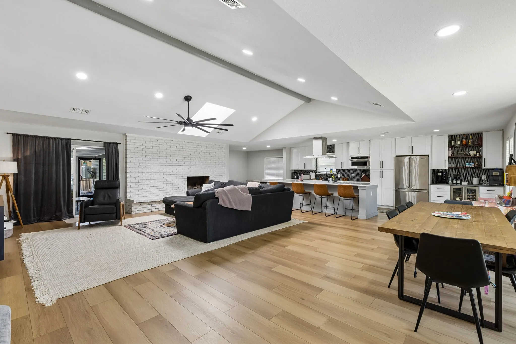 Vaulted ceiling with recessed lighting, skylight, and contemporary ceiling fan