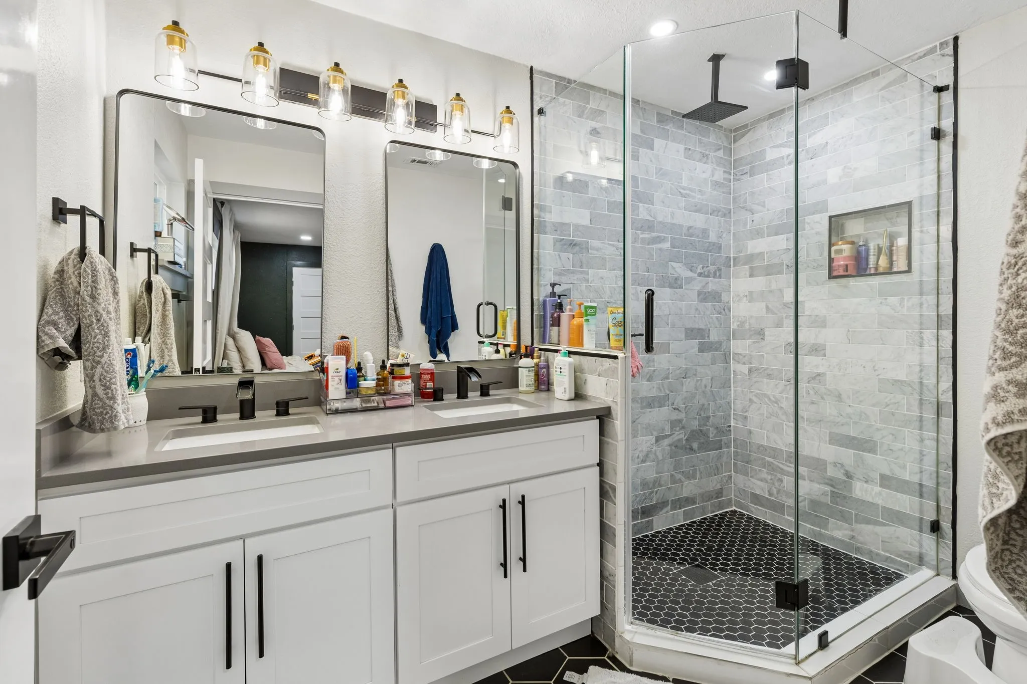 Dual vanity with white cabinetry, matte black hardware, and rectangular undermount sinks