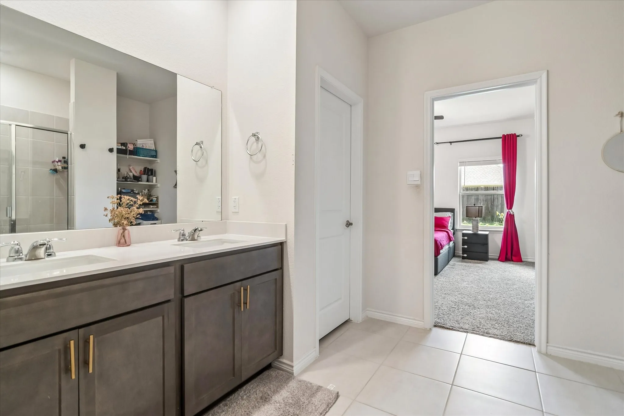 Double vanity with a light countertop, dual undermount sinks, and dark wood-finish cabinetry