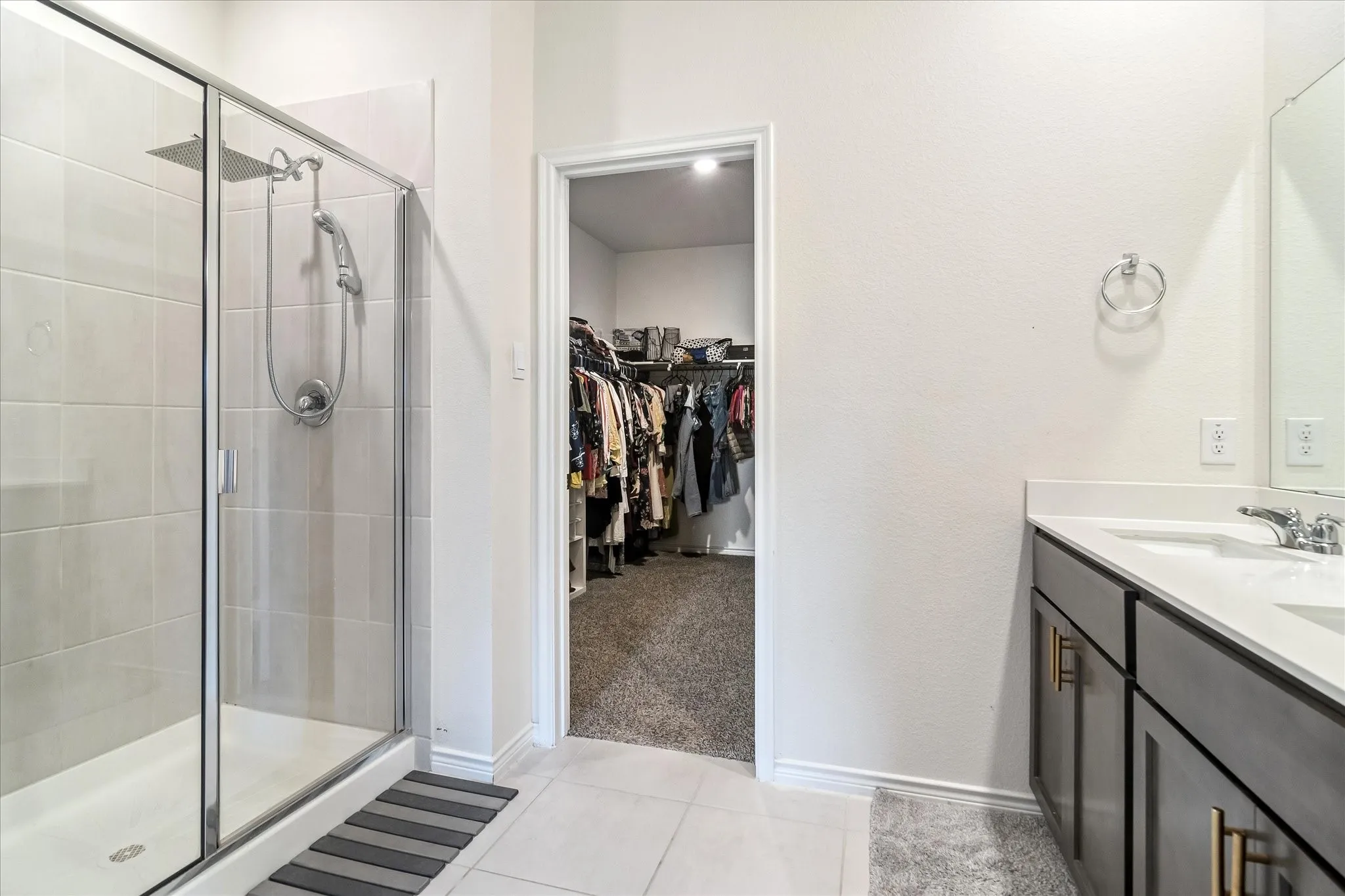 Walk-in shower with clear glass enclosure and subway tile surround