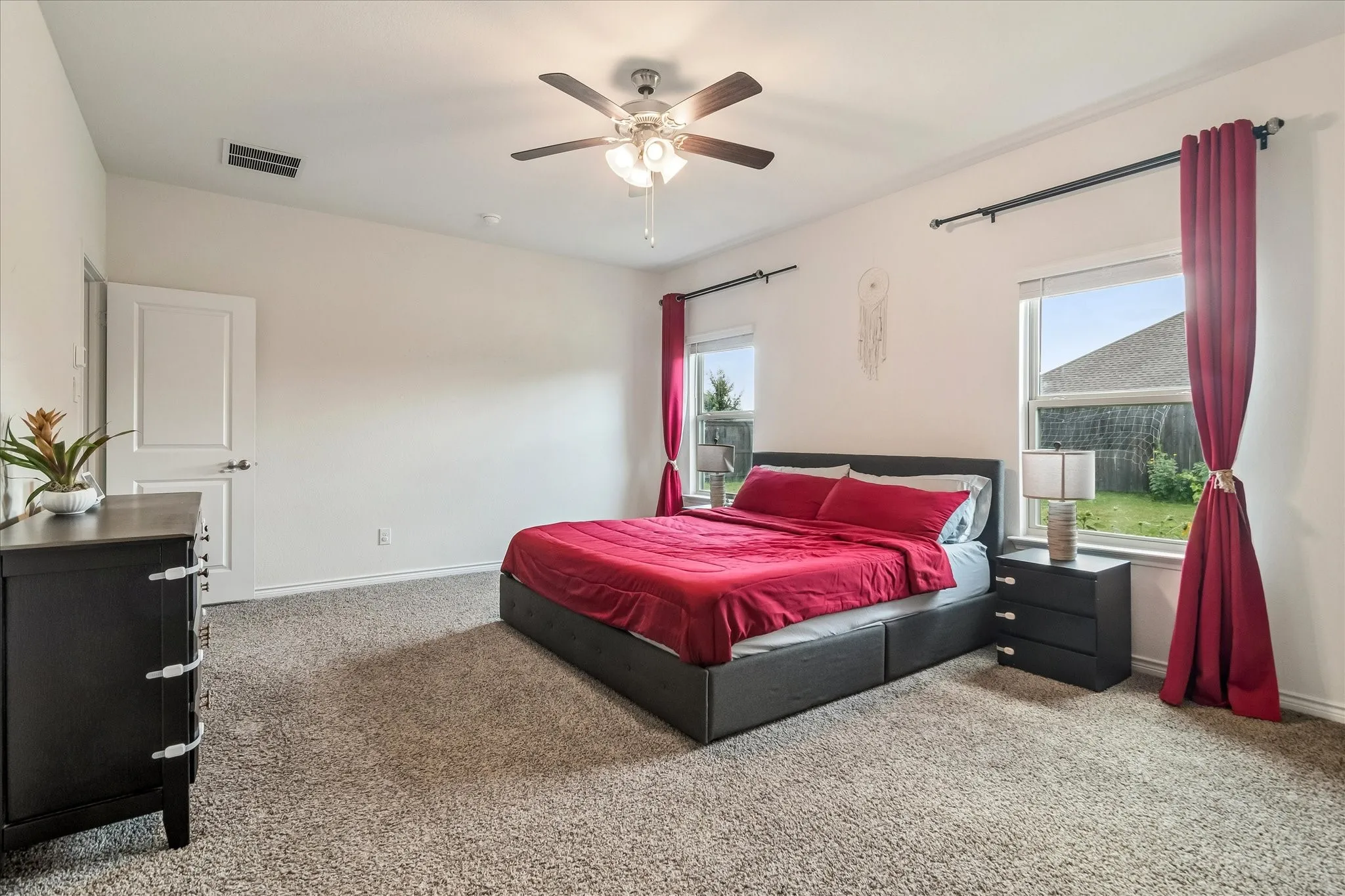 Carpeted bedroom featuring a vaulted ceiling and a ceiling fan with integrated lighting