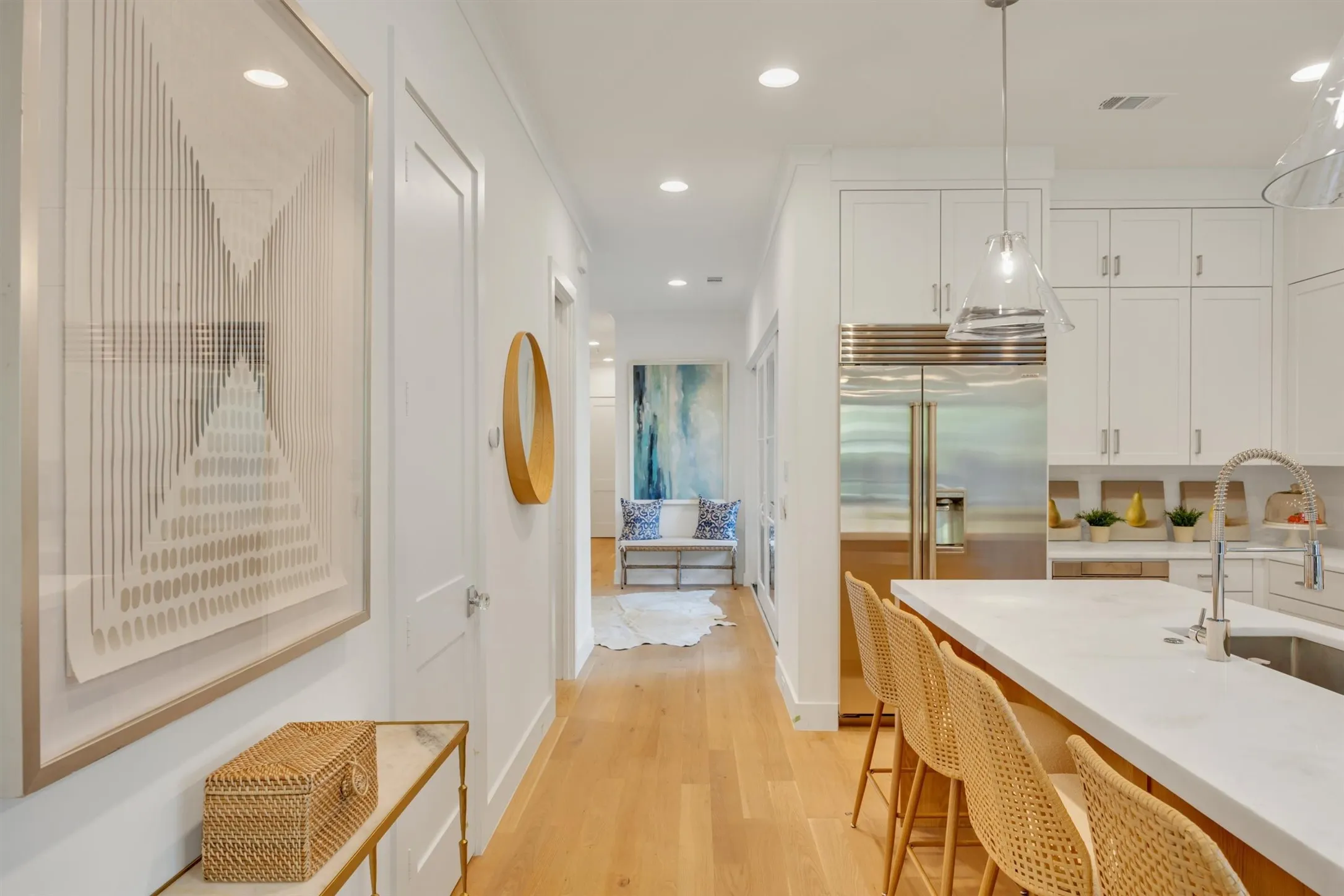 A view from the kitchen toward the powder bath, sitting are and toward the 4th bedroom/bath and garage.