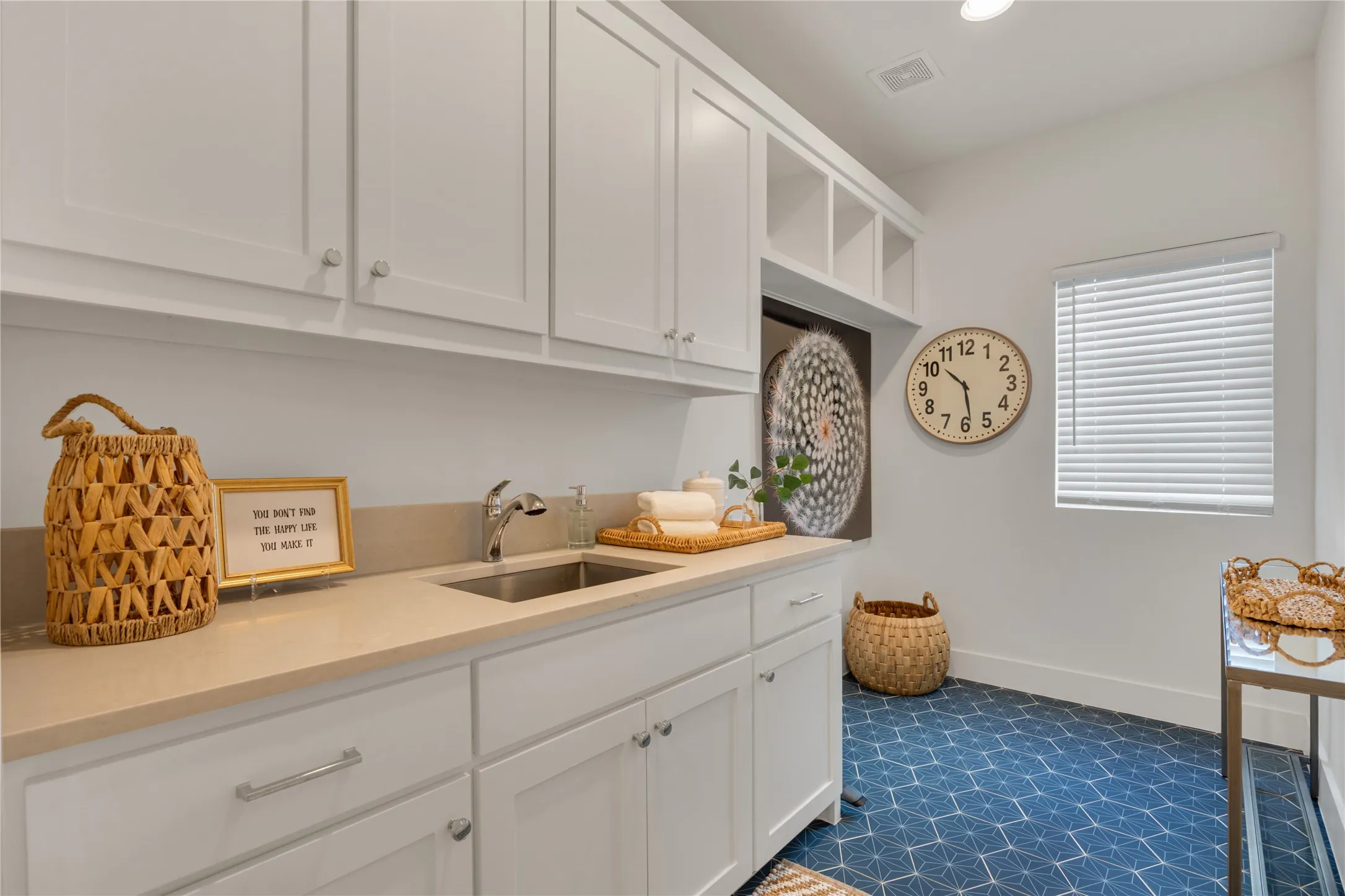 Spacious walk-in laundry room with cabinet storage and sink for hand wash items.