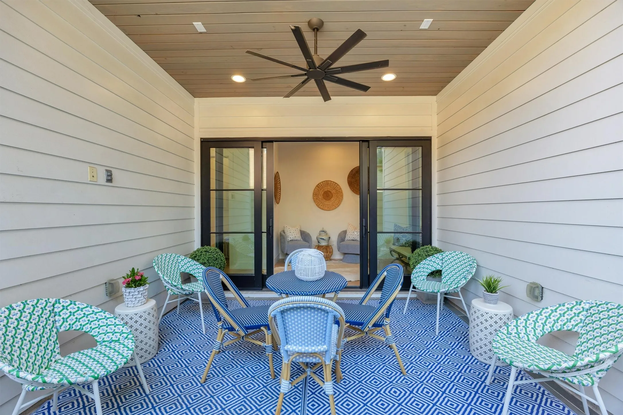 A beautiful set of sliding doors connects this outdoor patio seating area to the conversation spot just inside. There is wiring to hook up your television.