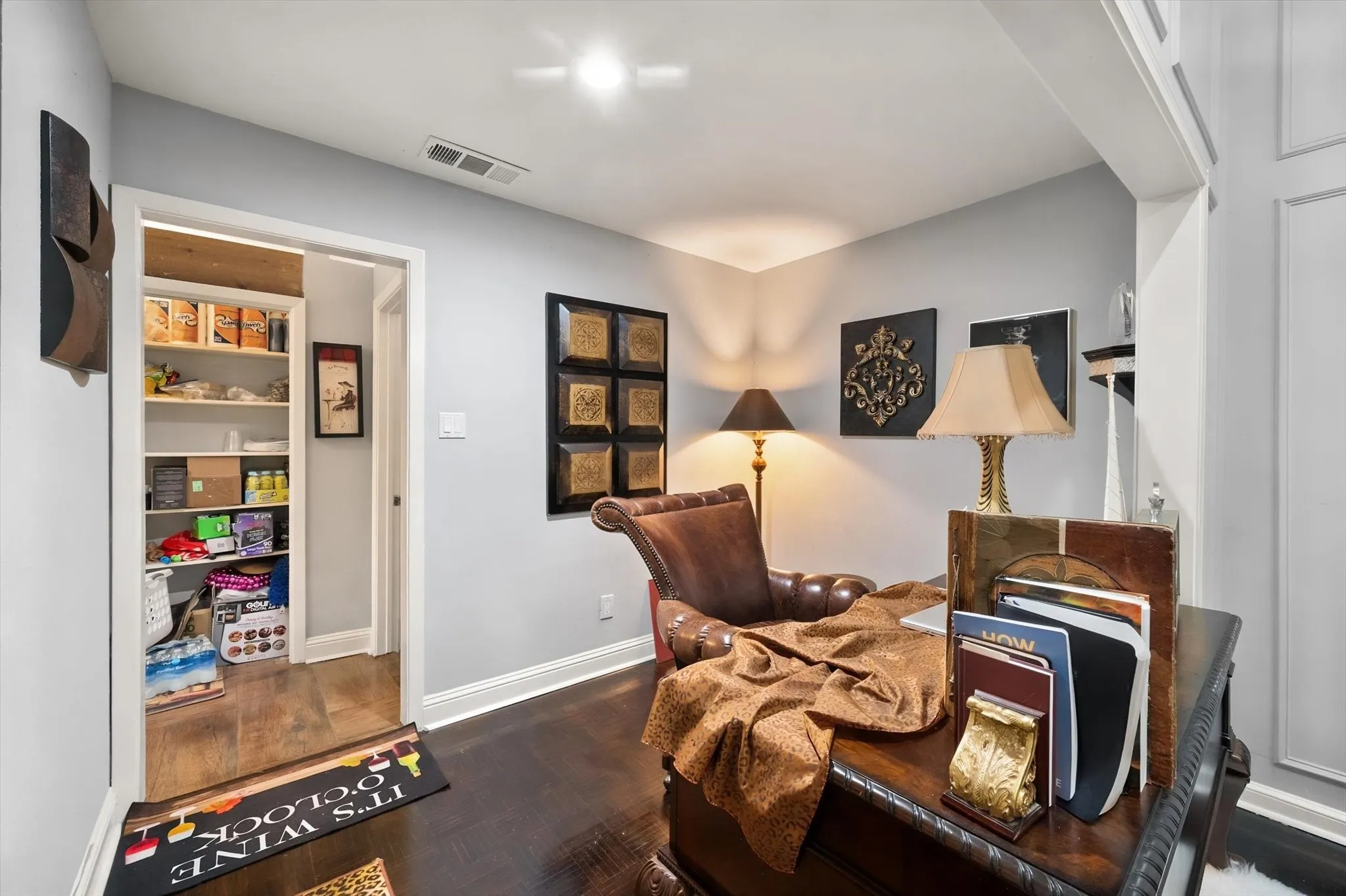 Deep wood-finish flooring, built-in shelving, white trim work, and light-toned wall finishes