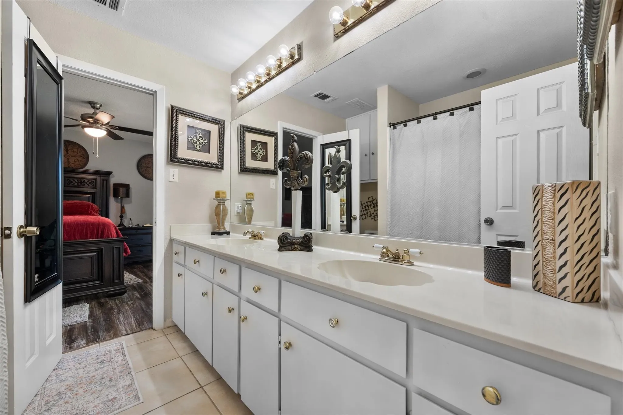 Dual vanity with white cabinetry, light-colored countertops, and integrated sinks