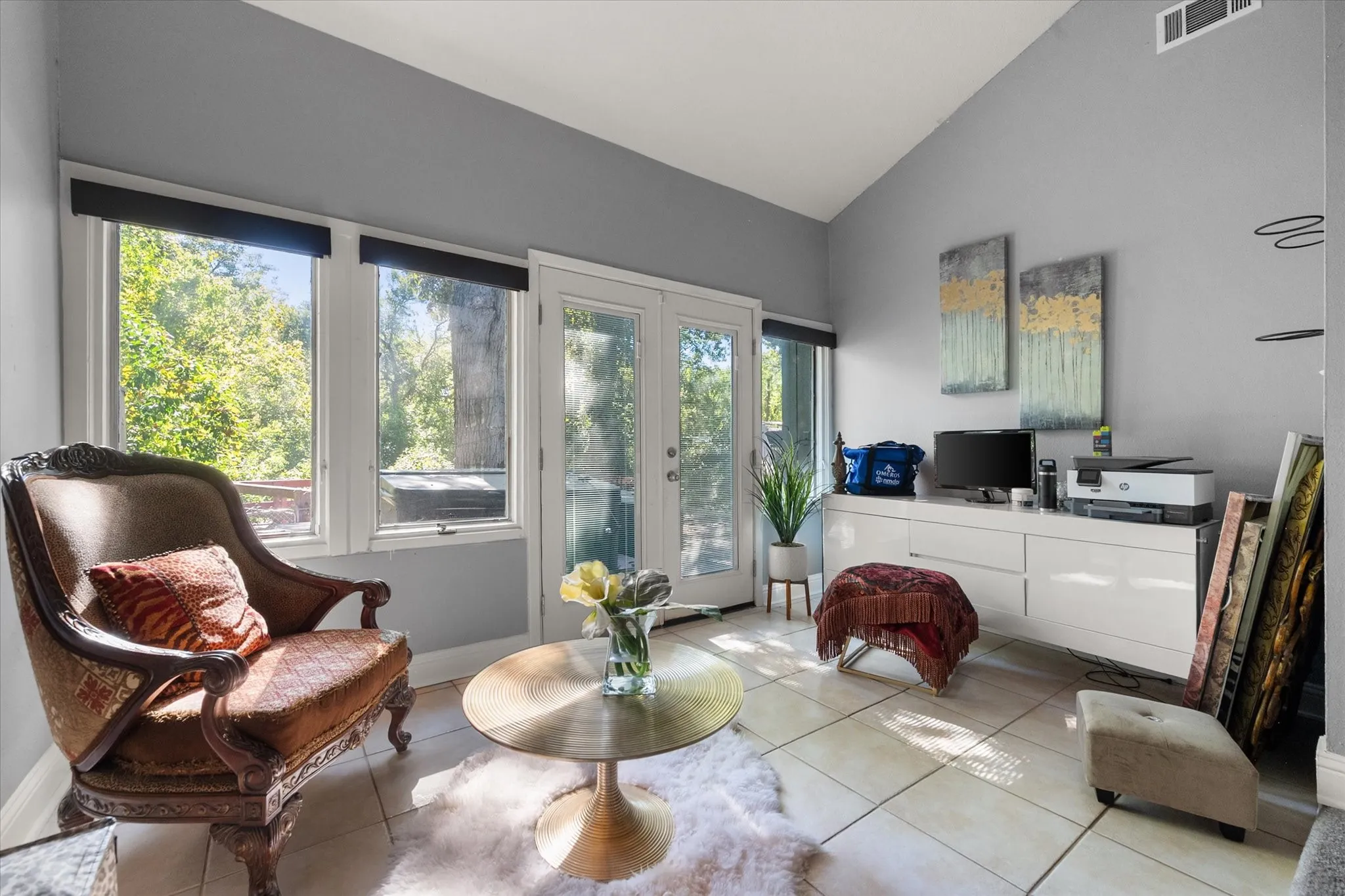 Vaulted ceilings, light-hued tile flooring, and multiple windows providing ambient light
