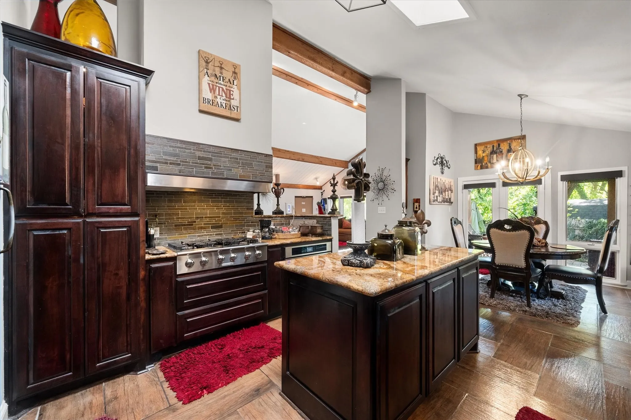 Kitchen featuring a large central island with a stone countertop, dark wood-finish cabinetry, stainless steel range with a ventilation hood, and wood-finish flooring