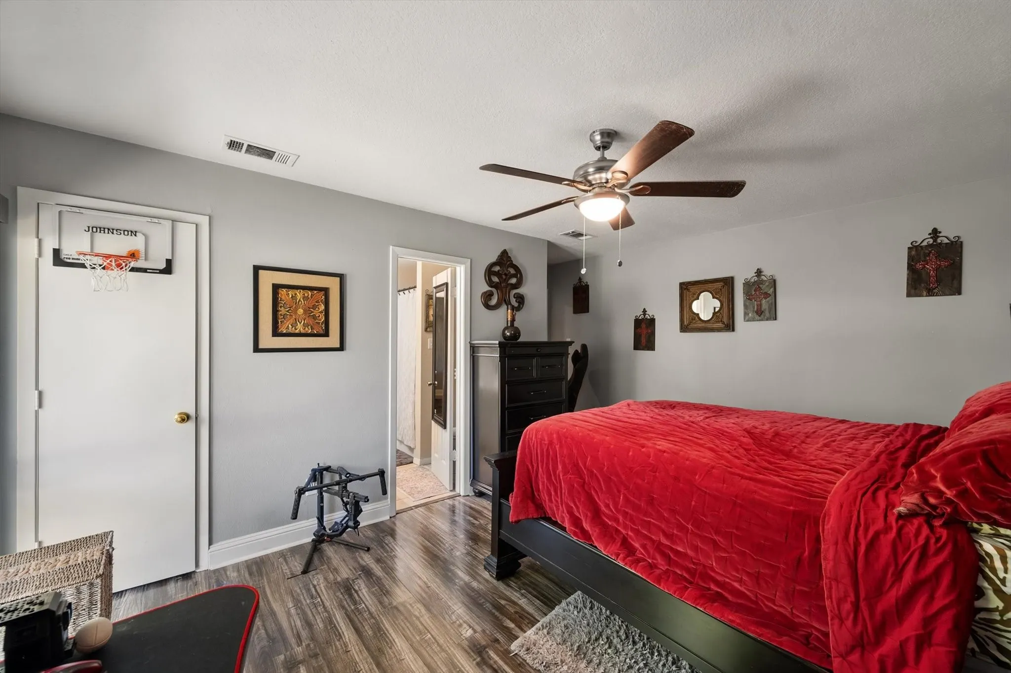 Wood-finish flooring, ceiling fan with integrated lighting, and light grey wall paint