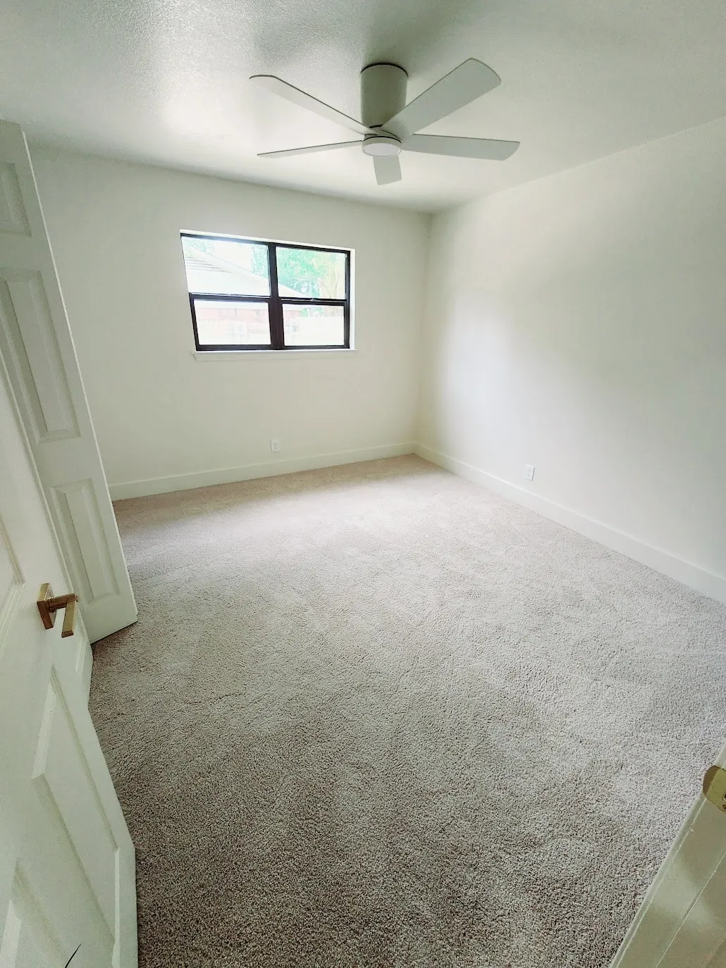 Recessed lighting, ceiling fan, neutral wall paint, window with dark framing, and light-colored carpeting