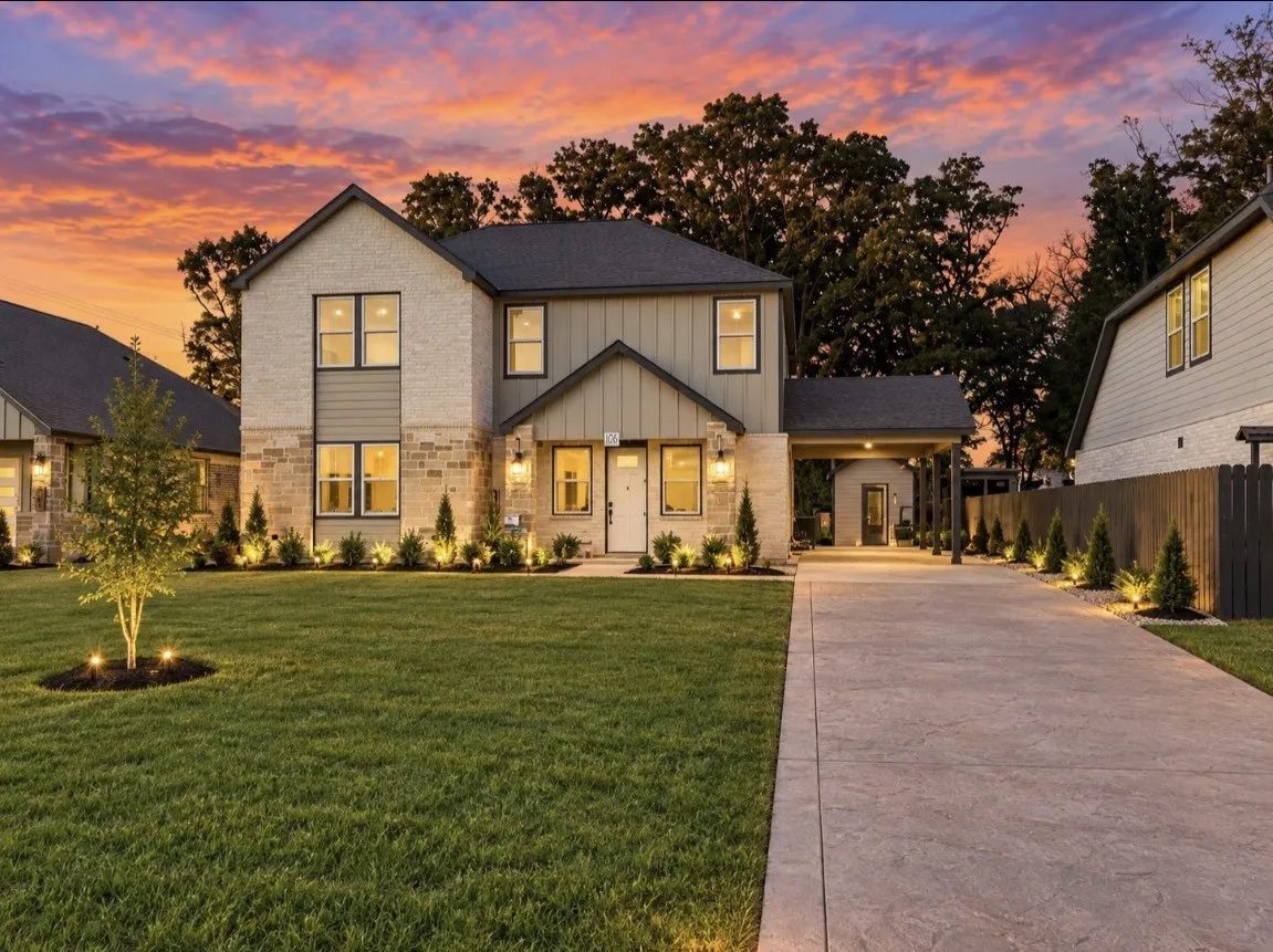 Two-story residence featuring brick and siding exterior, an extended covered porch entrance, and a stamped concrete driveway