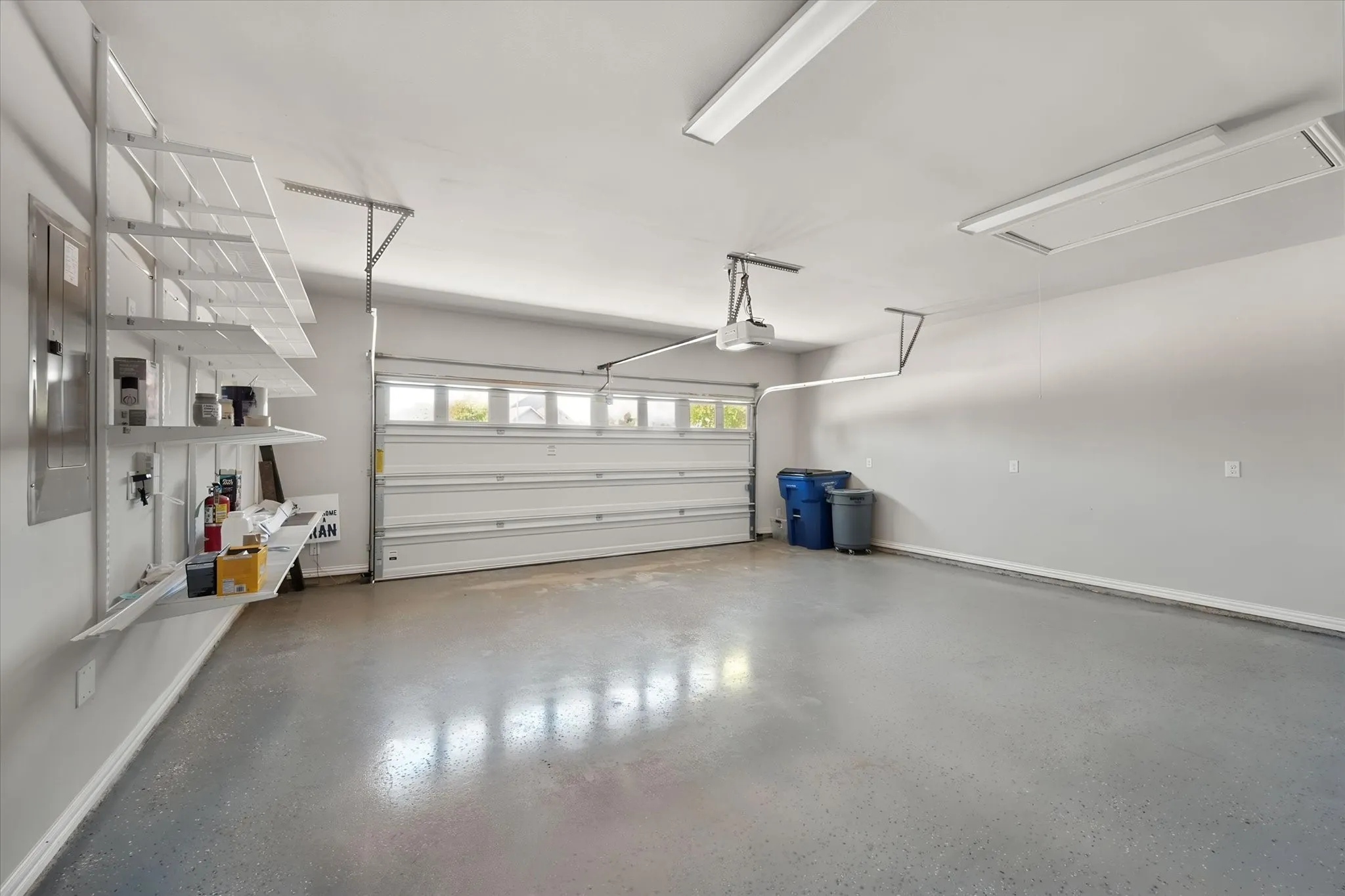 Two car garage features epoxy floor, built in shelving and attic pull down for additional storage.