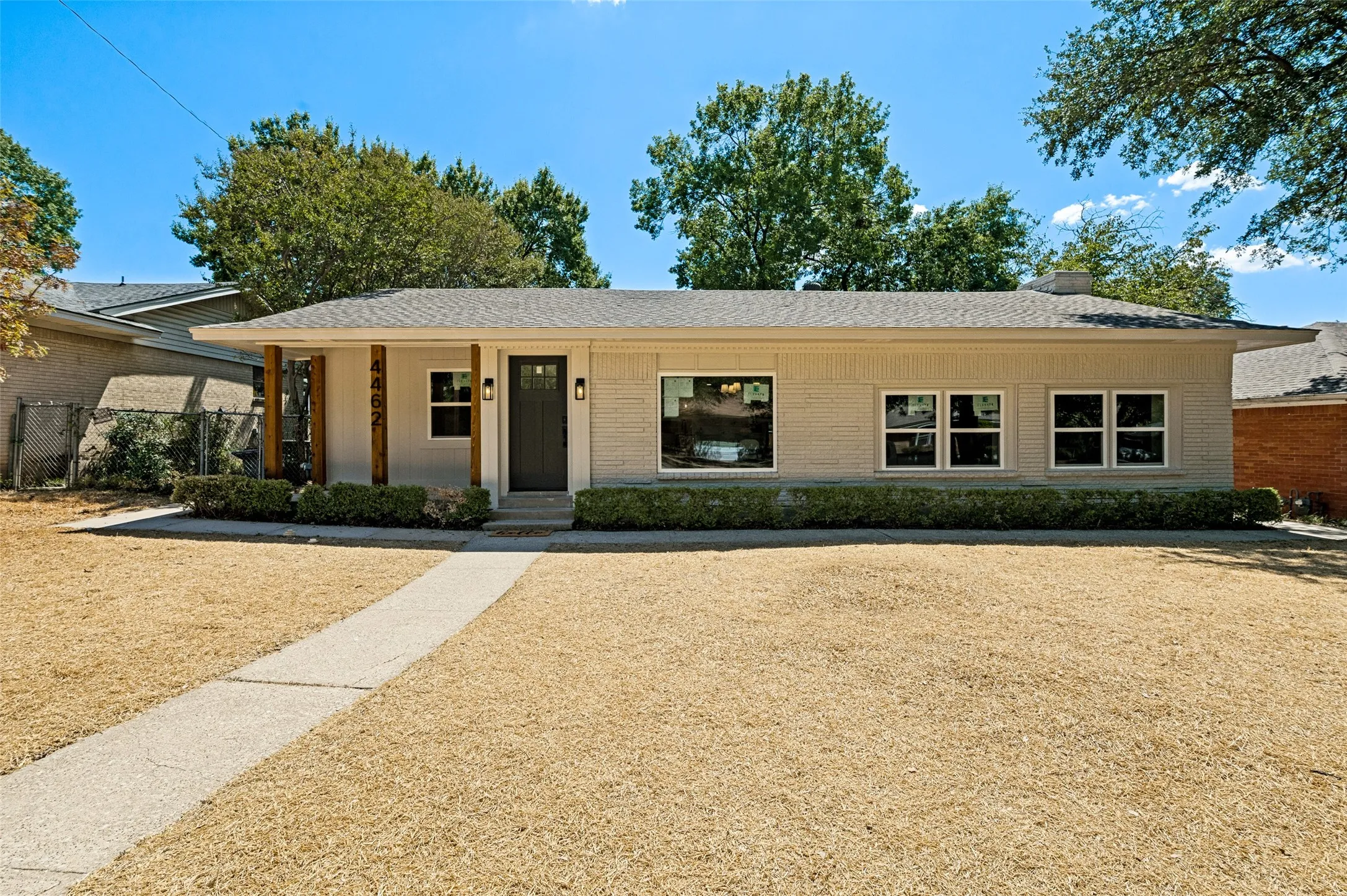 Single-story residence featuring a covered entry, wood support columns, and light-colored brick exterior