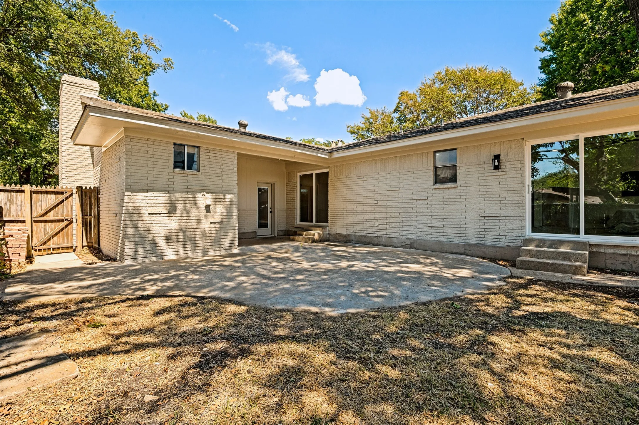 Exterior brick facade with a concrete patio