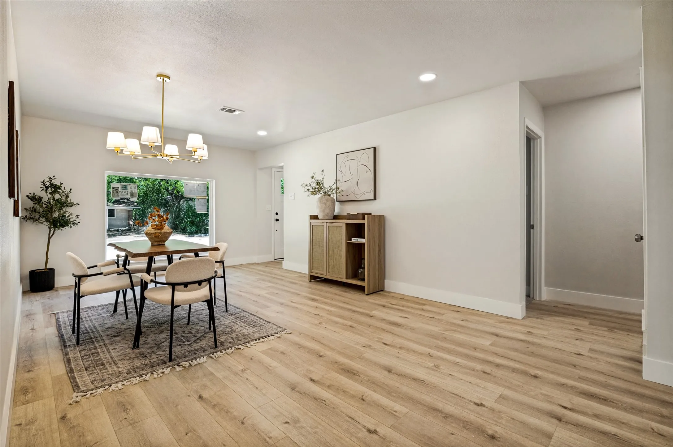 Spacious interior with wood-finish flooring, recessed lighting, and a large window