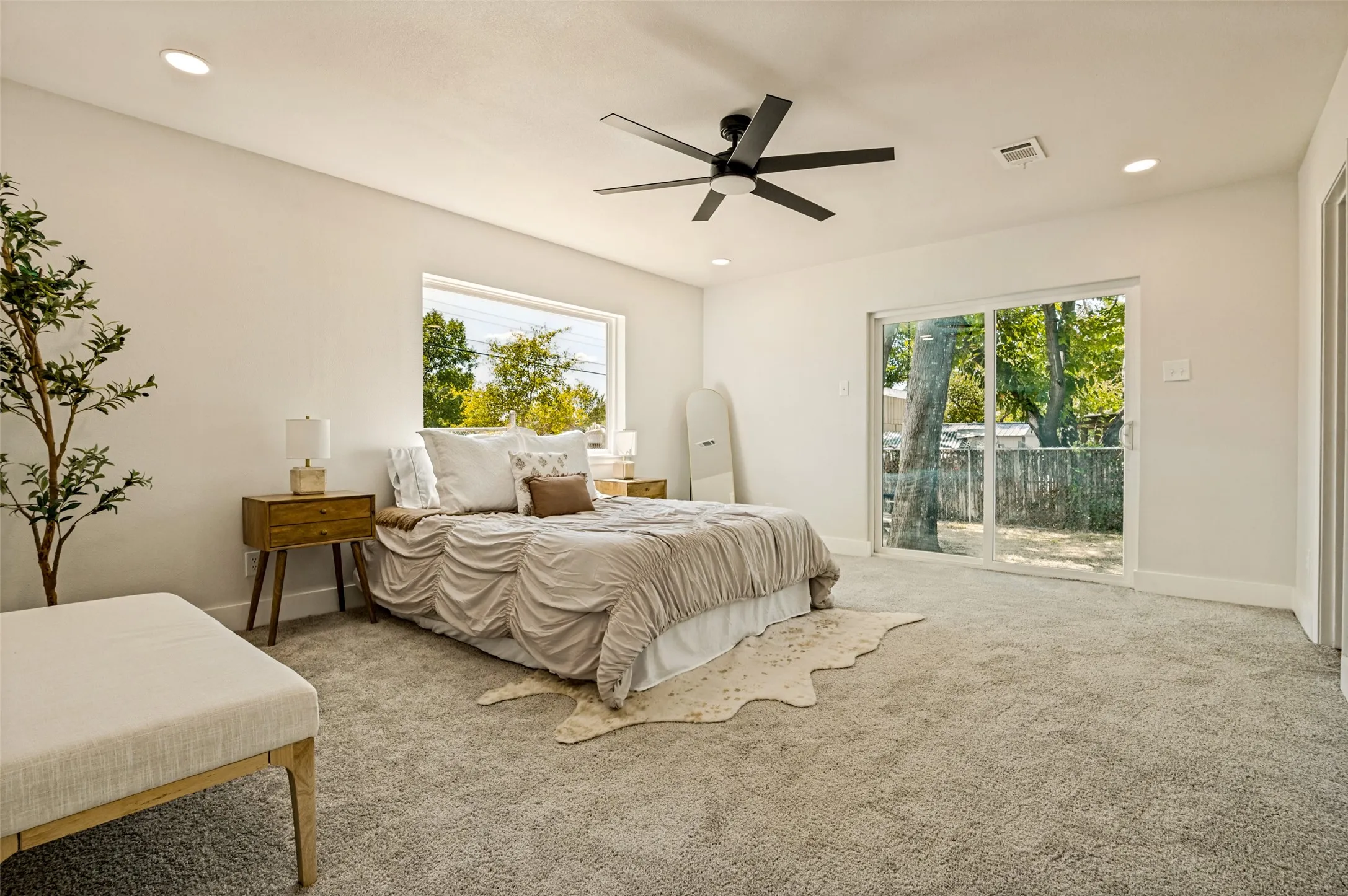 Plush carpeting, recessed lighting, and a modern ceiling fan