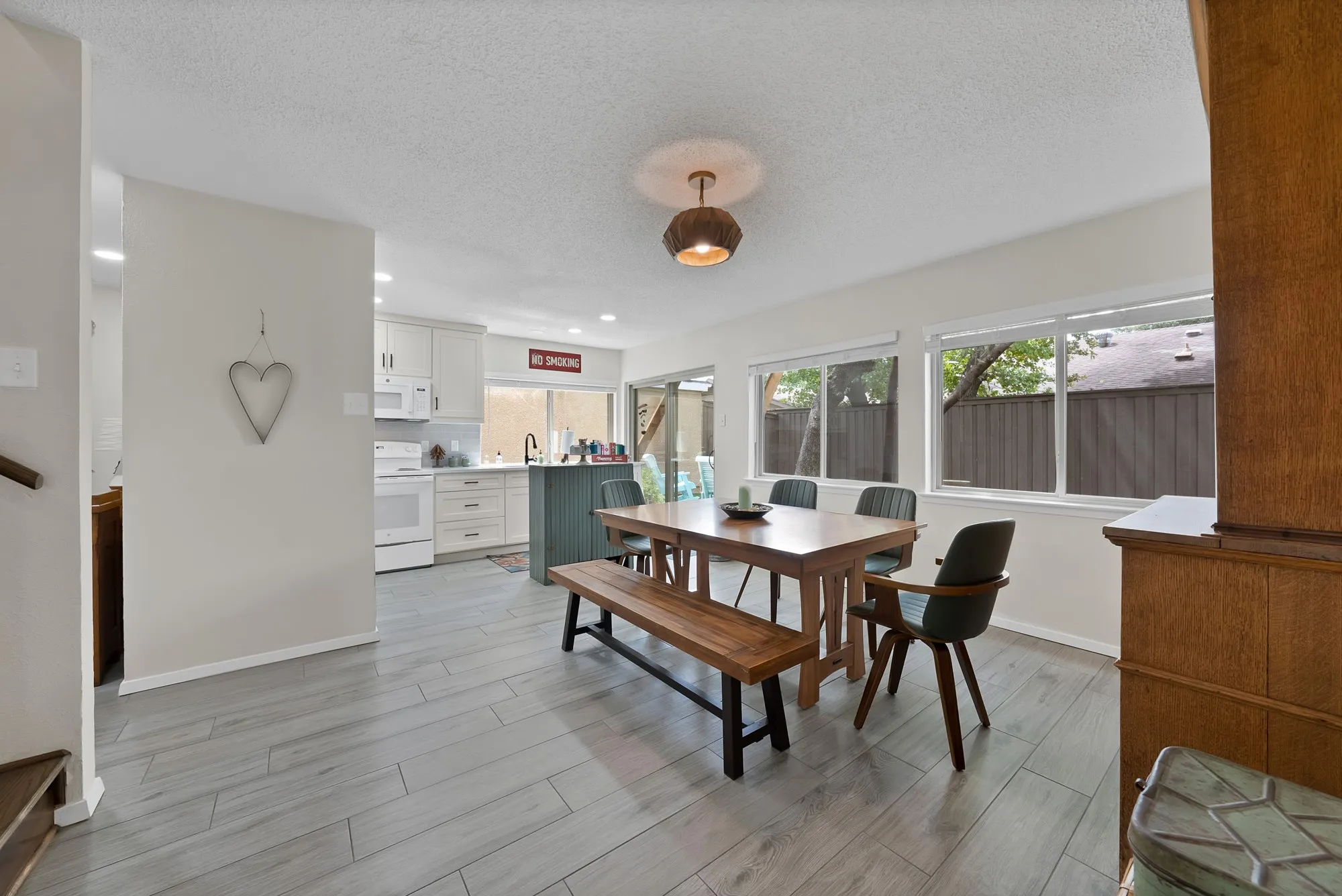 Kitchen and dining — Open concept kitchen with sliding glass door to backyard, blue painted kitchen island, and view into dining area with built-in hutch.