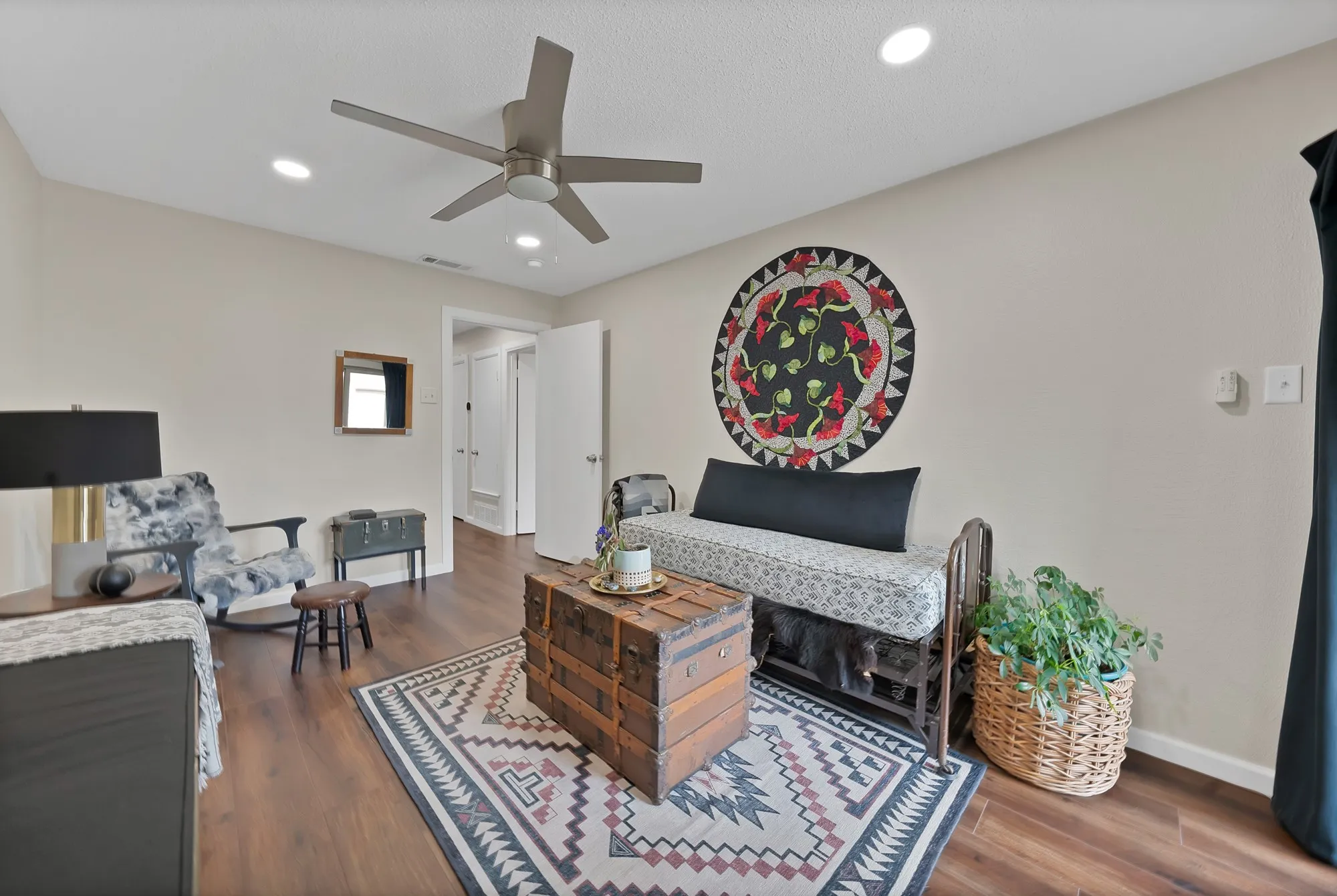 Bedroom — Wood look flooring with sliding glass door and ceiling fan with light kit.