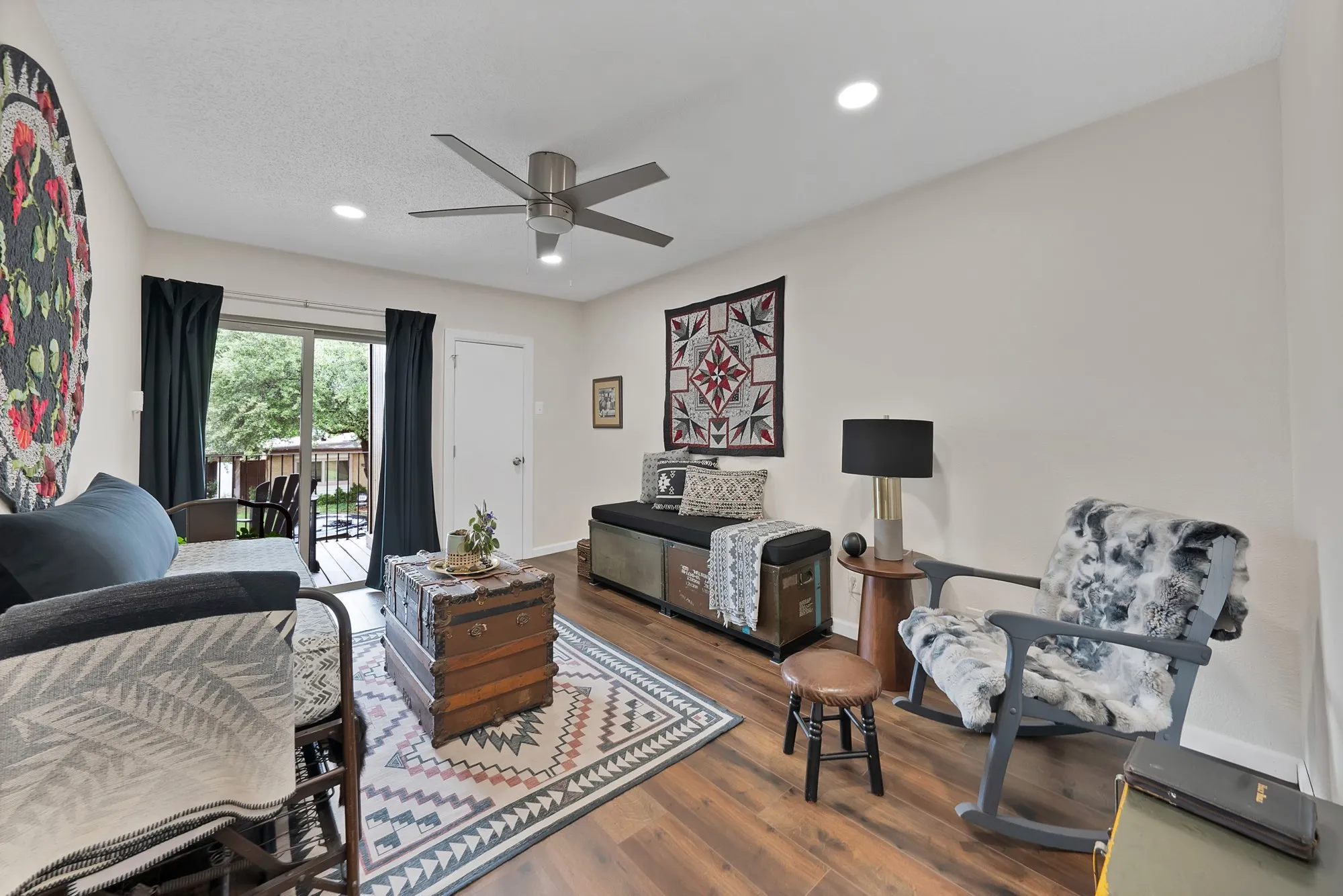Bedroom — Wood look flooring, ceiling fan, and doorway leading to hallway or closet space.