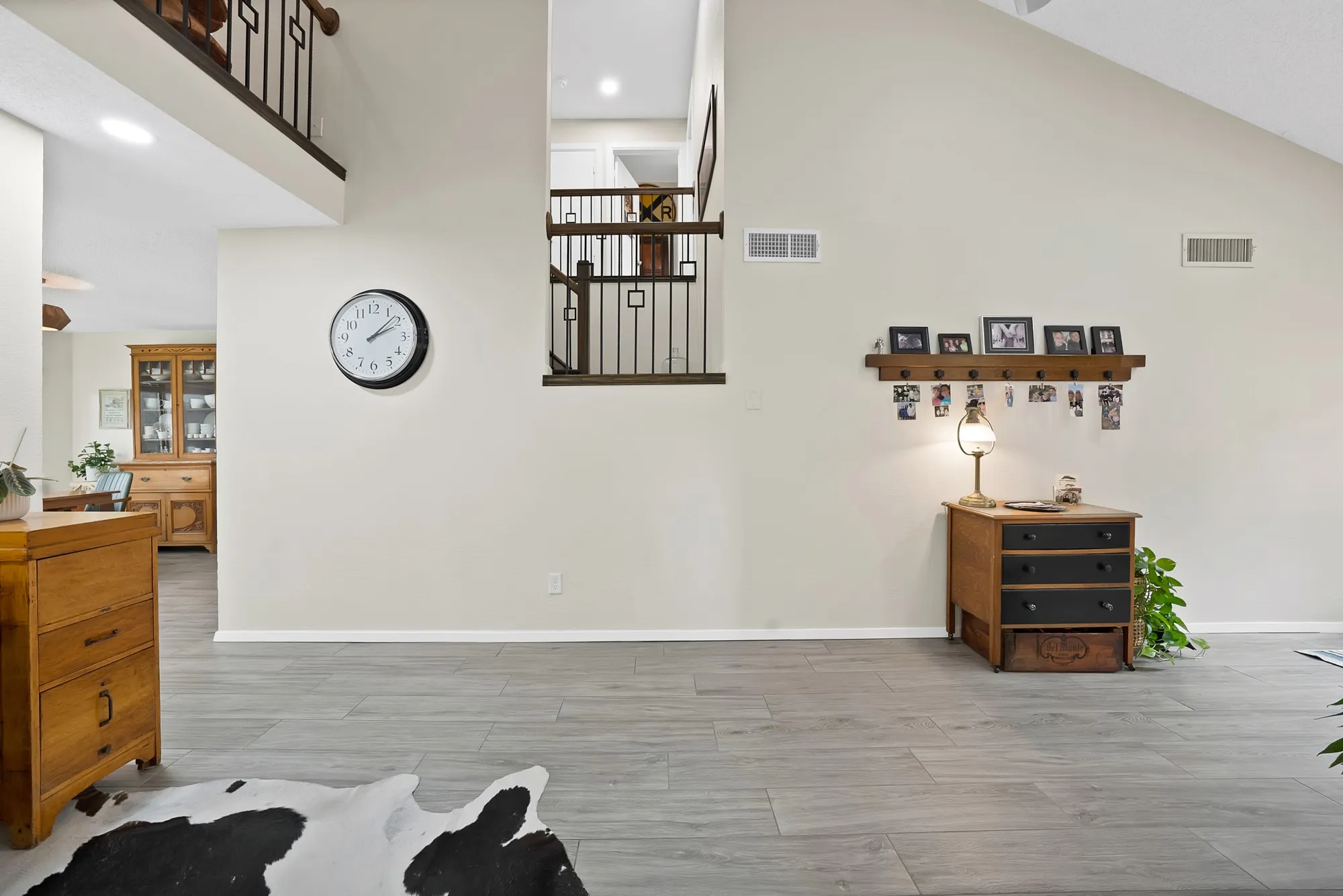 Entry foyer — Wood look tile flooring with view up to second floor iron stair railing and gallery​​‌​​​​‌​​‌‌​‌‌​​​‌‌​‌​‌​‌​​​‌​​ wall.