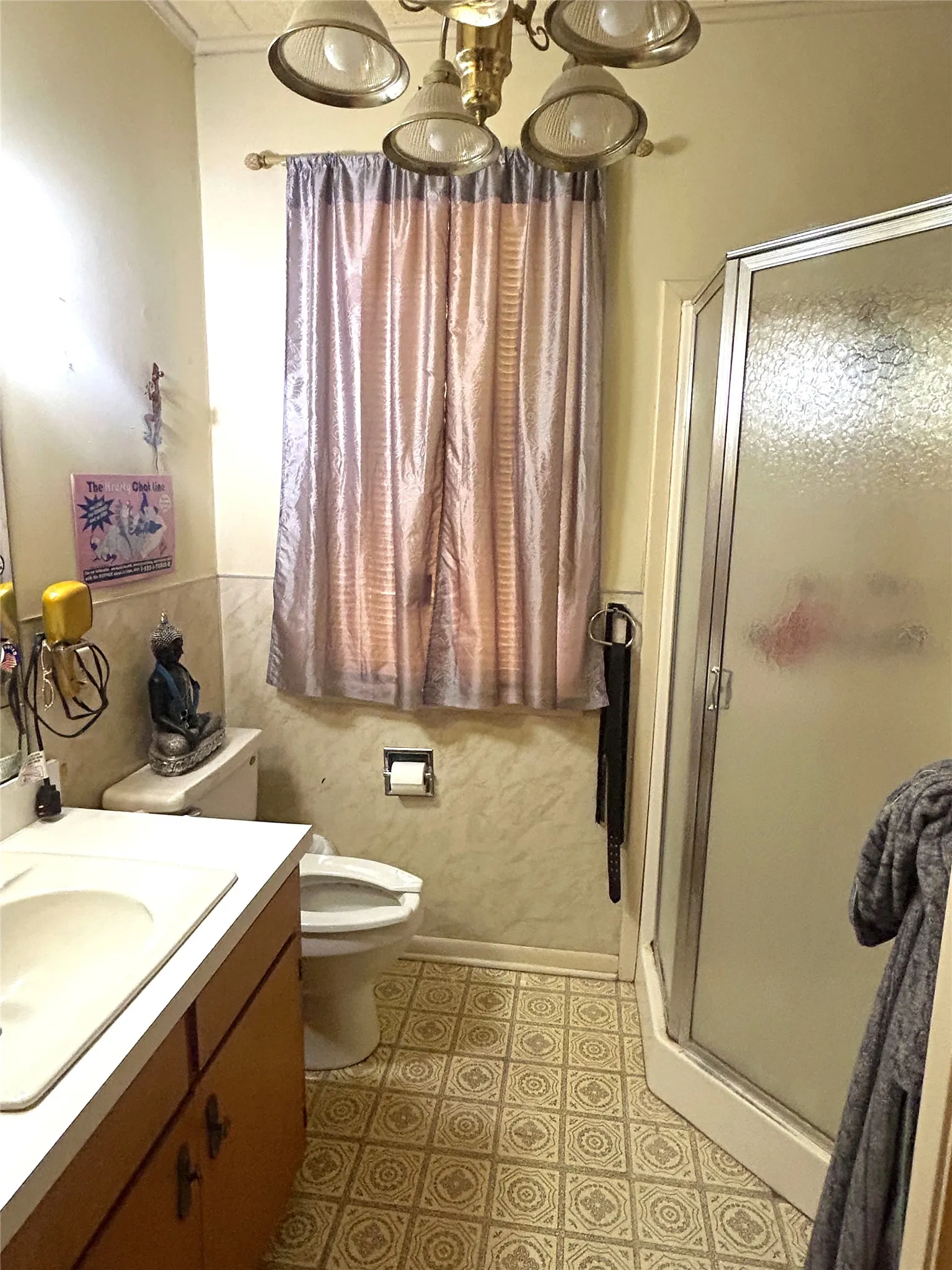 Vanity with integrated sink, patterned floor tile, and a stand-up shower with frosted glass