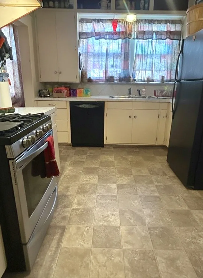Kitchen featuring tile flooring, white cabinetry, a stainless steel range, and a black dishwasher